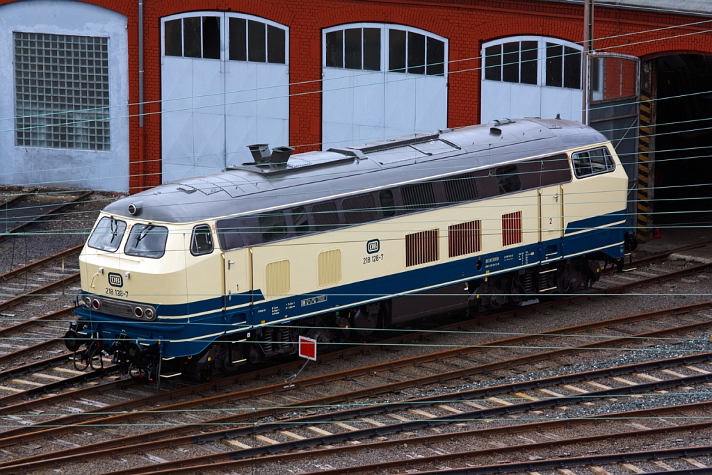 Die 218 128-7 steht am 21.07.2012 vor dem Siegener Lokschuppen, Blick vom Parkdeck der City Galerie.
Die Lok wurde 1971/72 bei Krupp unter der Fabriknummer 5149 gebaut, die Ausmusterung erfolgte am 27.05.2010.
Sie hat einen MTU-Motor vom Typ 12 V 956 TB 10  mit 1839 kW/ 2500 PS Leistung, die H�chstgeschwindigkeit betr�gt 140 km/h.