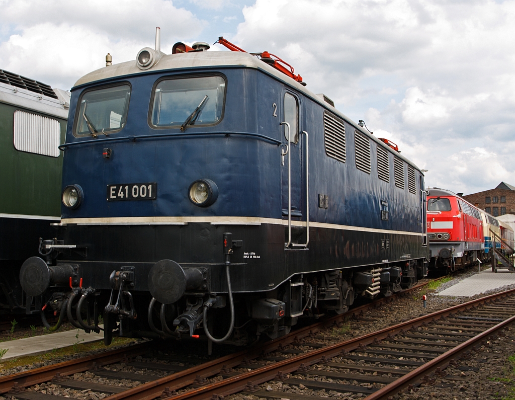 
Die DB E41 001 / 141 001-8 am 18.07.2012 im DB Museum Koblenz, in der Urspungsausf�hrung. Die Lokomotiven der BR E 41 waren bestimmt zur Bef�rderung von leichten G�terz�gen sowie zur Bef�rderung von Personenz�gen.  

Die Firmen Henschel und BBC entwickelten die laufachslose Lokomotive. Bereits ab Werk wurde die E 41 mit einer Wendezugsteuerung ausger�stet, um den Betrieb mit Steuerwagen zu erm�glichen.  

Die Lok wurde 1956 bei Henschel unter der Fabriknummer 29073 gebaut der elektr. Teil kam von BBC, ab 1968 wurde sie dann als 141 001-8 gef�hrt, die Ausmusterung erfolgte 2001. Die H�chstgeschwindigkeit betr�gt 120 km/h, die Stundenleistung 2.200 kW bei 84 km/h und das Dienstgewicht 66,4 t sie war die leichteste Baureihe innerhalb des Konzepts der elektrischen Einheitslokomotiven.