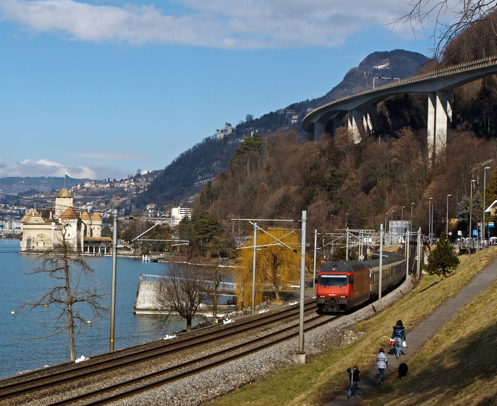 Re 460 066-4  Finse  zieht einen Schnellzug in Richtung Brig, hier am 26.02.2012 bei Clos du Moulin am Genfersee, hinten Ch�teau de Chillon, dahinter Montreux.