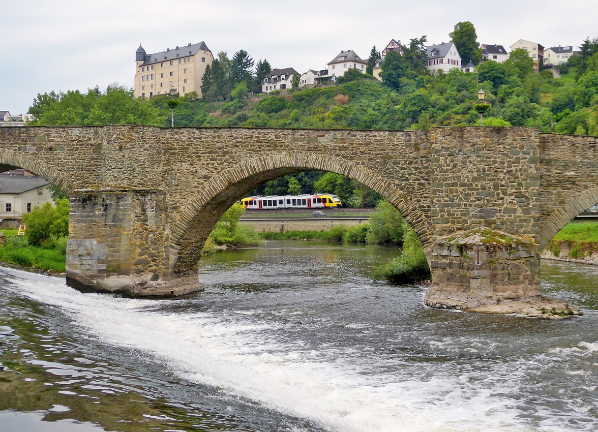. Der Br�ckenblick in Runkel - Eine HLB (Hessische Landesbahn) LINT 41 Doppeleinheit hat am 26.05.2014 den Bahnhof Runkel verlassen und f�hrt an der Lahn entlang in Richtung Limburg an der Lahn, gesehen durch den Bogen der steinernen Lahnbr�cke aus dem 15. Jh in Runkel, w�hrend oben die Burg Schadeck aus dem 13. Jh zu sehen ist. (Hans)