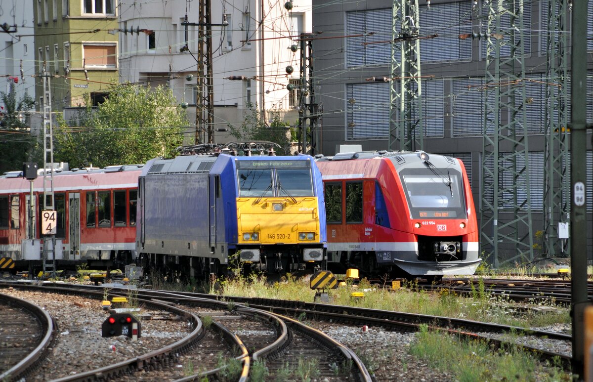 146 520-2 mit Beschriftung im Richtungsanzeiger:  Erstes Fahrzeug . Die Lok ist bereits bei verschiedenen Eigentümern gewesen; den Text in der Anzeige kann ich daher nicht zuordnen.
Hinter der Lok fährt der 622 554 durch, in Ulm an 30.07.2022.