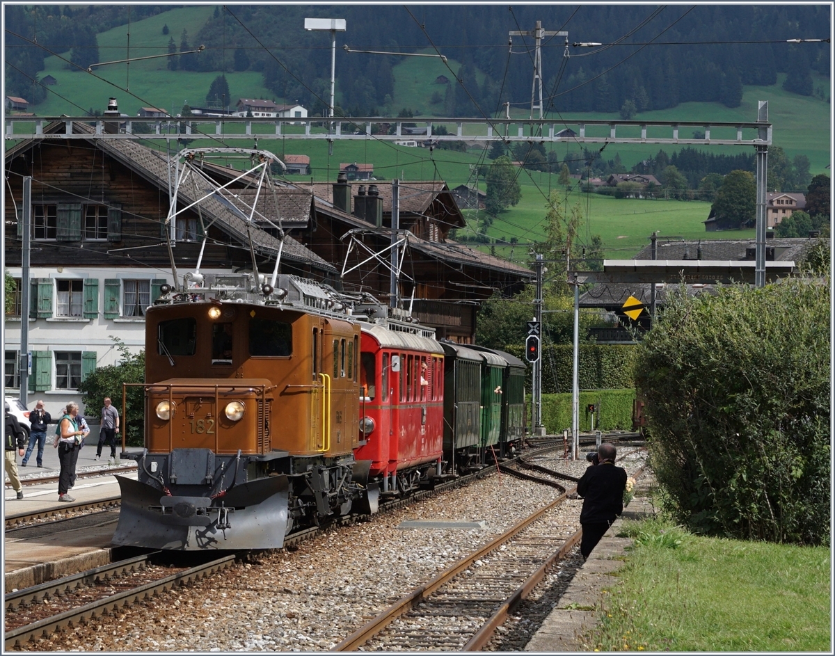 50 Jahre Blonay Chamby - MEGA BERNINA FESTIVAL:  B�ndner Tag im Saaneland  - die RhB Ge 4/4  182 und der RhB ABe 4/4 35 warten in Saanen auf den Gegenzug mit der Ge 4/4  81. Die geniale Idee war, dass beide Z�ge  Nase an Nase  vor dem schmucken Stationsgeb�ude halten, und ein einmaliges Motiv bilden, was dann auch betriebliche perfekt geklappt hatte, aber kaum zu fotografieren war.
14. Sept. 2018