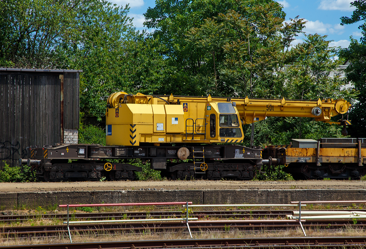 
50t-KIROW-Schienenkran TELVAR 50-1 der Hering Bau (Burbach),  Schweres Nebenfahrzeug Nr. 97 82 35 501 19-1 ist am 30.05.2020 beim Bahnhof Bonn-Beul abegestellt.

Der Eisenbahndrehkran wurde 1992 von der Schwermaschinenbau KIROW Leipzig GmbH  (bis 1990 zum TAKRAF Kombinat) unter der Fabriknummer 1 gebaut. Er war wohl der erste gebaute Kran nach der Reprivatisierung 1990,  bis dahin bestand das TAKRAF Kombinat aus 26 Einzelbetrieben, zu denen auch der VEB Schwermaschinenbau S. M. Kirow Leipzig gehörte.

TECHNISCHE DATEN:
Spurweite: 1.435 mm
Eigengewicht: 120 t
Länge über Puffer: 13.600 mm
Achsanzahl: 6 (in zwei Drehgestellen)
Drehzapfenabstand: 6.000 mm
Achsabstand in den Einzeldrehgestellen: 3.000 mm (2x 1.500 mm)
Treib- und Laufraddurchmesser: 920 mm (neu)
Fahrgeschwindigkeit im Zugverband: 120 km/h
Fahrgeschwindigkeit mit Eigenantrieb: 20 km/h ohne Last 6 km/h mit Last
Zugelassen als Schwerwagen für Streckenklasse: CS04 und höher
kleinster befahrbarer Radius: 80 m
Bremse: KE-GP

Tragfähigkeiten:
bei  8,00 m Ausladung vor Puffer:  50 t, freistehend: 46 t
bei 18,00 m Ausladung vor Puffer: 17 t, freistehend: 46 t
Hubgeschwindigkeit: bis 30 t 5,3m/min, bis 50 t 3,5 m/min
