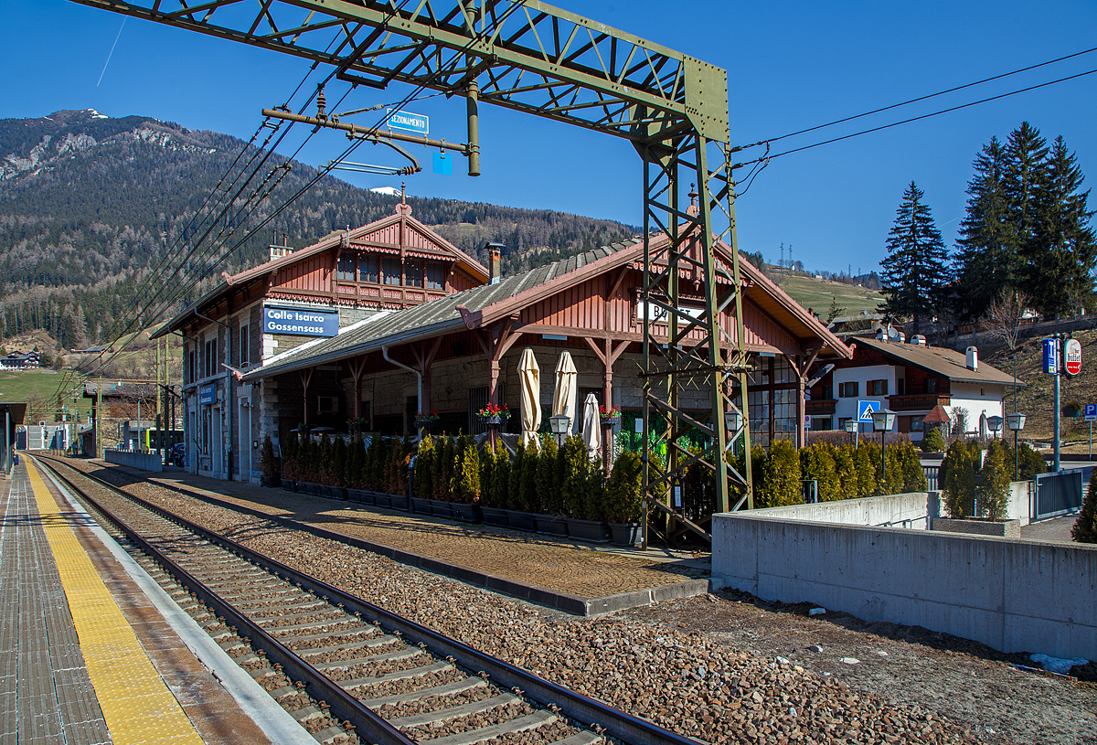 Blick auf den Bahnhof Gossensaß/Colle Isarco am 27.03.2022.
Der Bahnhof Gossensaß (auch Gossensass; italienisch Stazione di Colle Isarco) befindet sich an der Brennerbahn in Südtirol (italienisch Alto Adige), amtlich Autonome Provinz Bozen – Südtirol.

Der Bahnhof Gossensaß ist der erste Haltepunkt im Wipptal südlich des Brennerpasses, zu dem die Bahnstrecke von hier aus über den Pflerschtunnel ansteigt. Er liegt auf 1.066,9 m Höhe nahe dem Zentrum von Gossensaß, dem Hauptort der Gemeinde Brenner, und der durch das Dorf führenden SS 12 (der alten Brennerpass-Straße). 

Der Bahnhof wurde 1867 zusammen mit dem gesamten Abschnitt der Brennerbahn zwischen Innsbruck und Bozen in Betrieb genommen. Durch ihn erlebte Gossensaß bis zum Ersten Weltkrieg seine Blütezeit als bekannter Touristenort. Er konkurrierte mit Orten wie St. Moritz oder Chamonix. 

Das Aufnahmegebäude war zunächst noch relativ kompakt gehalten, wurde wegen der vielen Touristen jedoch noch im 19. Jahrhundert durch einen südlichen Anbau erweitert. Das ursprüngliche Gebäude weist eine Verkleidung aus Grauwacke auf, während dekorative Details wie die Fensterfassungen in weißem Kalkstein gehalten sind. Straßenseitig ist es durch einen in sorgfältigen Details gearbeiteten Dachgiebel aus Holz gestaltet. Der Anbau ist in Brixner Granit gemauert und sticht durch eine hölzerne Veranda hervor. In dem sich heute das Buffet befindet und man auch den Espresso genießen kann. Das Gebäude steht seit dem Jahr 2000 unter Denkmalschutz.

Der Bahnhof Gossensaß wird durch Regionalzüge der Trenitalia sowie der SAD bedient, die auch Busverbindungen zum Bahnhof betreibt. Die Regionalzüge fahren in beide Richtung (Brenner bzw. Bozen) im Stundentakt und werden zu Hauptverkehrszeiten durch Regionalexpresszüge verdichtet.

Uns hat es in Gossensaß sehr gut gefallen, es war einfach zu kurz, so dass wir gerne wiedermal dort hinfahren wollen. Für die drei Tage haben wir uns ein Südtirol/Alto Adige Ticket (eine Mobilcard für 3 Tage) am Automat für 23,00 Euro geholt. So konnten wir mit diesem Ticket Südtirol mit der Bahn erkunden. 
