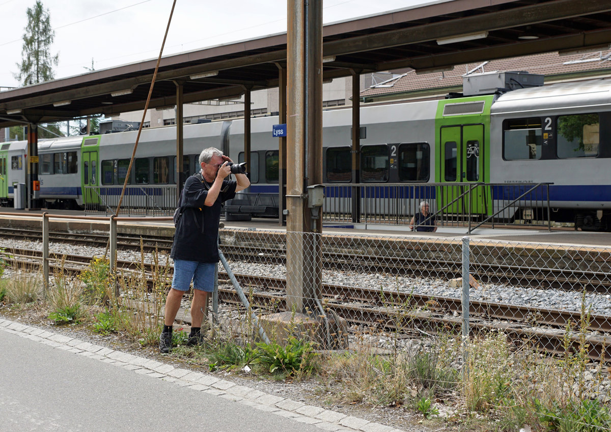 Dampftage 2018 von Lyss
Mein Lieblingsbild der besonderen Art.
Hallo Armin
Auch das gehört zum Fotografieren von Bahnen.
Kaum in Lyss angekommen, konnte ich per Zufall zu meiner grossen Freude unseren lieben Freund Stefan Wohlfahrt aus Blonay in  action  fotografieren.
Bin nicht ganz sicher, glaube aber, dass er die  Französin  im Visier hatte.
Im Hintergrund erkennbar ist seine liebe Frau Christine. 
Lieber Gruss
Walter Ruetsch
