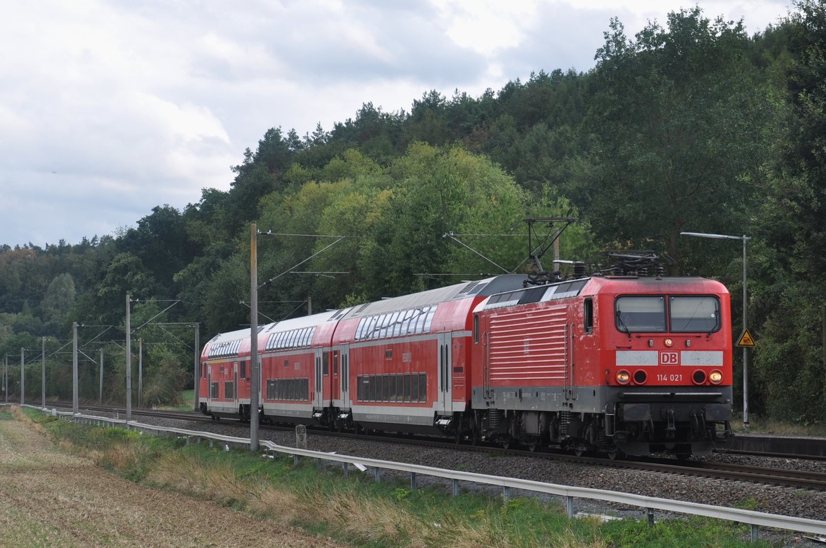 Der 27.08.2018 war ein besonderer Tag für mich: Meine Lieblingslok 114 021 war auf meiner Heimatstrecke (der Main-Lahn-Bahn) unterwegs, und das auch noch vor einer falsch herum gereihten Garnitur! Normal verkehren hier zehn Loks der Baureihe 143 und nur selten bespannt eine der insgesamt zweiundzwanzig Frankfurter 114er einen Umlauf auf der Main-Lahn-Bahn. Dass genau 114 021 diesen Umlauf zog, war also echt großes Glück. :)

Hier erreicht 114 021 als RB22 (15268) den Haltepunkt Lindenholzhausen, leider ohne funktionierende Zugzielanzeige. 