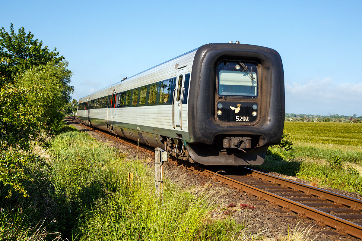 
Der DSB IC3 – MFB 5292 / FF 5492 / MFA 5092 f�hrt am 12.06.2015 als EC 31 (Hamburg - L�beck - Puttgarten - R�dby - Kopenhagen), hier auf der „Vogelfluglinie“ beim B� 69,8 der Bahnstrecke L�beck–Puttgarten (KBS 141) bei Gro�enbrode .

Die DSB-Baureihe MF 5000 ist ein f�r die DSB (Danske Statsbaner / D�nische Staatsbahn) vom Hersteller ABB Scandia in Randers (D�nemark) entworfener, dreiteiliger Dieseltriebzug f�r den �berregionalen Verkehr.  Umgangssprachlich werden sie auch, wie auch andere Triebwagen mit Gummiw�lsten, als Gumminase genannt. 

Die Bauart ist unter der Bezeichnung IC3 in D�nemark seit 1989 weit verbreitet. Seit 1993 existiert eine Weiterentwicklung mit der Bezeichnung IR4 (siehe DSB-Baureihe ER); ein vierteiliger Elektrotriebzug, der mit dem IC3 im Zugverband gefahren werden kann. 

Seine Besonderheit ist ein wegklappbarer F�hrerstand, der zu einem Durchgang um funktionier bar ist. Auf diese Weise lassen sich maximal f�nf IC3- bzw. IR4-Einheiten zu einem durchg�ngigen Zug kuppeln. Der Wagen�bergang ist dank des Gummiwulstes zugluftdicht. Die Gummiw�lste werden im Regelfall mit Druckluft gef�llt und damit in Form gehalten, zum Kuppeln und Entkuppeln werden sie entleert.

Eine Einheit besteht aus drei Wagenk�sten (Motorwagen MFA 50xx, Mittelwagen FF 54xx und Motorwagen MFB 52xx), die auf insgesamt vier Drehgestellen (davon zwei Jakobs-Drehgestelle) ruhen. Urspr�nglich hatten sie vier luftgek�hlte 8-Zylinder Deutz Dieselmotoren vom Typ BF8L513CP mit 294 kW Leistung. Die Kraft�bertragung erfolgt mechanisch.Ab 2005 wurdendie Fahrzeuge remotorisiert und s�mtliche Motoren durch neue wassergek�hlte V-6-Zylinder Deutz Dieselmotoren vom Typ vom Typ TCD2015  (Euro III) mit je 330 kW ersetzt. Im Zuge der Remotorisierung wurden die urspr�nglichen 5-Gang-Automatikgetriebe vom Typ Ecomat 5HP600 des Herstellers ZF Friedrichshafen gegen neue 12-Gang-Automatikgetriebe vom Typ AS Tronic Rail (Variante 12 AS 2303 R), ebenfalls von ZF ersetzt. 

Die Triebz�ge sind mit dem Zugsicherungssystem ATC f�r D�nemark sowie die Einheiten MF 5076 bis 5092 mit PZB 90 (Indusi) f�r Deutschland ausgestattet. Diese werden unter anderem f�r die EuroCity-Z�ge auf der Vogelfluglinie von Kopenhagen �ber Puttgarden sowie von Aarhus �ber Padborg nach Hamburg eingesetzt.

Technische Daten:
Hersteller:  ABB Scandia
Baujahre:  1989–1998
Spurweite:  1435 mm (Normalspur)
Achsformel:  (1A)+(A1)+(1A)+(A1)
L�nge �ber Kupplung:  58.820 mm  (20,54 m / 17,74 m / 20,54m)
H�he:  3.850 mm
Breite:  3.100 mm
Dienstmasse:  97,0 t
H�chstgeschwindigkeit:  180 km/h
Installierte Leistung:  1.320 kW / 1795 PS (urspr�nglich 1.176 kW)
Beschleunigung:  bis zu 1,0 m/s2
Dieselmotoren 4 � V 6-Zylinder Deutz TCD2015 (Euro III) mit 330 kW
Leistungs�bertragung:  mechanisch,12-Gang-Automatikgetriebe ZF-AS Tronic Rail (12 AS 2303 R)
Zugbremse:  Druckluftbremse, Magnetschienenbremse
Kupplungstyp:  Scharfenbergkupplung
Sitzpl�tze:  16 (1. Klasse) / 122 (2. Klasse)
Klappsitze: 6
Fu�bodenh�he:  1,30 m
