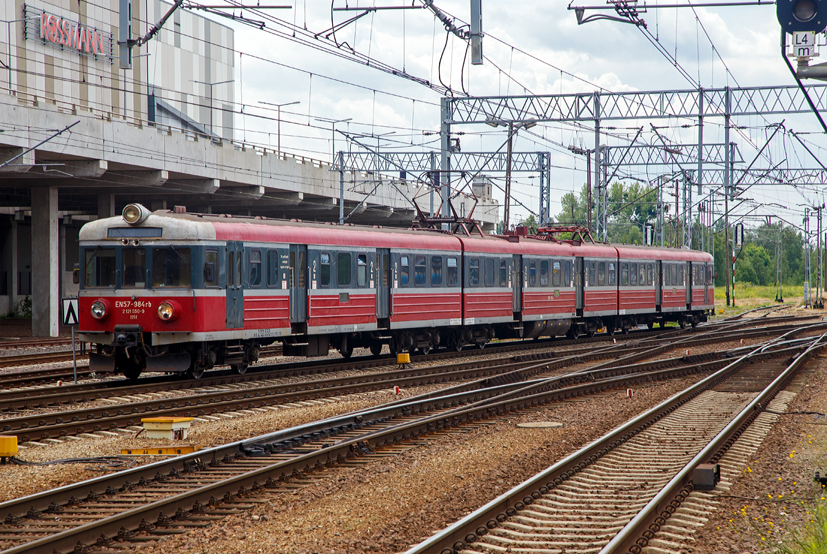 
Der Elektrotriebzug – Elektryczne zespoły trakcyjne EN57-984 (94 51 2 121 550-9 PL-PREG 1151 / 94 51 2 121 549-1 PL-PREG und 94 51 2 121 548-3 PL-PREG) ein Triebzug vom Typ Pafawag 5B/6B der POLREGIO (Przewozy Regionalne Sp. z o.o.) fährt am 25.06.2017 vom Hauptbahnhof Posen (Poznań Główny) in den Abstellbereich. 

Der Triebzug wurde 1974 von PaFaWag in Wrocław unter der Fabriknummer 517 gebaut und als EN57-984 an die PKP geliefert, seit 2009 ist er bei der POLREGIO. Es ist ein Ur EN 57er.

Die Baureihe EN57 ist eine Baureihe dreiteiliger elektrischer Triebwagen ursprünglich der Polnischen Staatsbahnen (PKP). Seitdem der Nahverkehr aus diesen herausgelöst wurde, fahren sie für die jeweilige Nachfolgegesellschaft, hauptsächlich Przewozy Regionalne, teilweise erheblich modernisiert. Dieser ist jedoch noch im Auslieferzustand.

Die Elektrischen-Triebzüge EN57 bestehen aus einer festen Konfiguration von drei Fahrzeugteilen, zwei Steuerwagen (Herstellerbezeichnung 5B) und einem Triebwagen (Herstellerbezeichnung 6A) dazwischen. Scharfenbergkupplungen an den Enden ermöglicht das Zusammenkuppeln mehrerer Triebzüge.

TECHNISCHE DATEN:
Nummerierung (Auslieferzustand): 001–130; 601–1828; 1900–1953
Gebaute Anzahl: 1412
Hersteller: PaFaWag in Wrocław
Baujahre: 1961–1993
Spurweite: 1.435 mm (Normalspur)
Achsformel: 2'2'+Bo'Bo'+2'2'
Länge über Kupplung: 64.970 mm
Breite: 2.880 mm
Höhe: 3.720 mm
Treibraddurchmesser: 1.000 mm
Laufraddurchmesser: 920 mm
Dienstgewicht: 126,5 t
Höchstgeschwindigkeit: 120 km/h (ab der 2. Lieferserie)
Leistung: 4×175 kW (2.Serie)
Stromsystem: 3 kV DC
Anzahl der Fahrmotoren: 4
Kupplungstyp: Scharfenbergkupplung
Sitzplätze: 212
