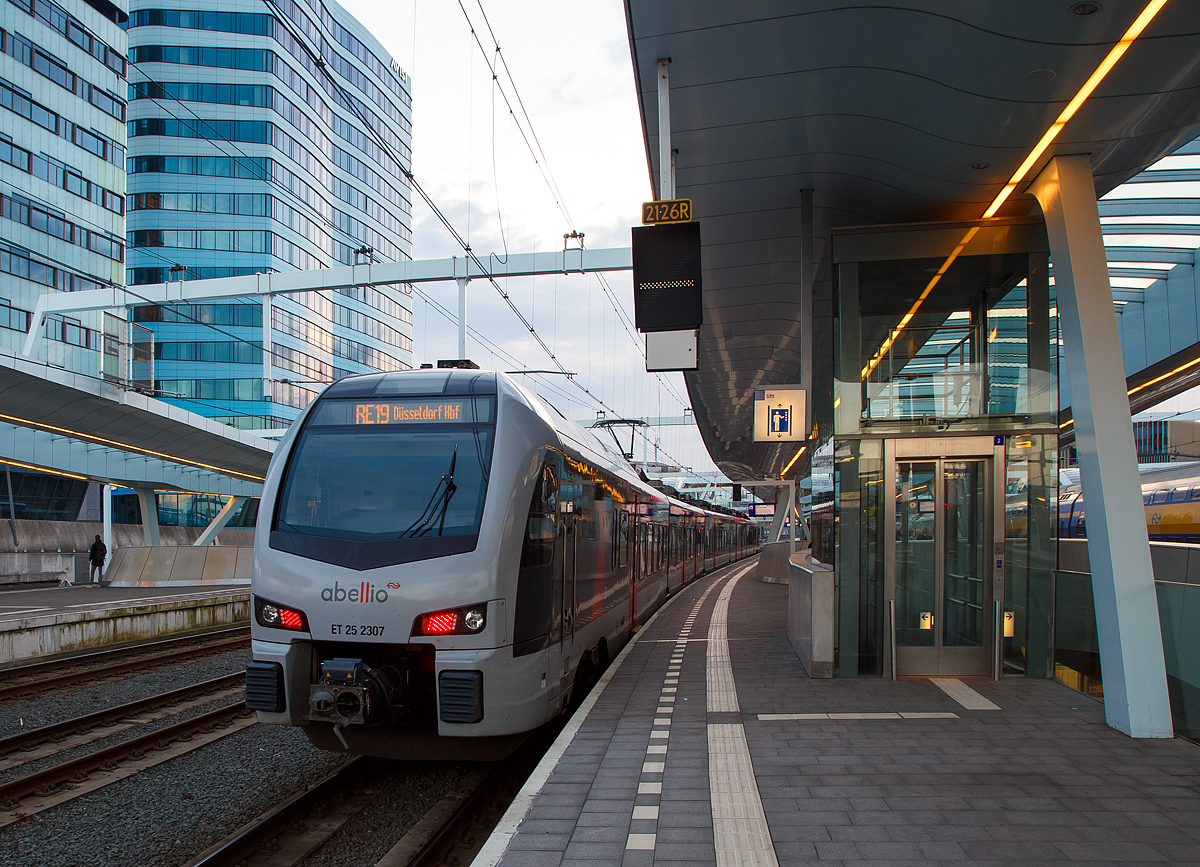 
Der ET 25 2307 ein fünfteiliger Mehrsystem Stadler FLIRT 3 (BR 2429) Abellio Rail NRW steht am 31.03.2018, als RE 19  Rhein-IJssel-Express , im Bahnhof Arnhem Centraal (Arnheim) zur Abfahrt nach Düsseldorf bereit. 

Diese fünfteiligen Stadler FLIRT 3 sind elektrische Mehrsystem-Triebzüge (15 kV/25 kV/1,5 kV) mit Niederlande-Zulassung. Die Abellio Rail NRW hat neun dieser Mehrsystem FLIRT für den Einsatz auf dieser Strecke. Auf der Verbindung gibt es drei Stromsysteme und zwar: 15 kV 16,7 Hz AC von Düsseldorf bis Elten, 25 kV 50 Hz DC von Elten bis Zevenaar (Übergang zur Betuweroute) und 1,5 kV DC von Zevenaar bis Arnhem.