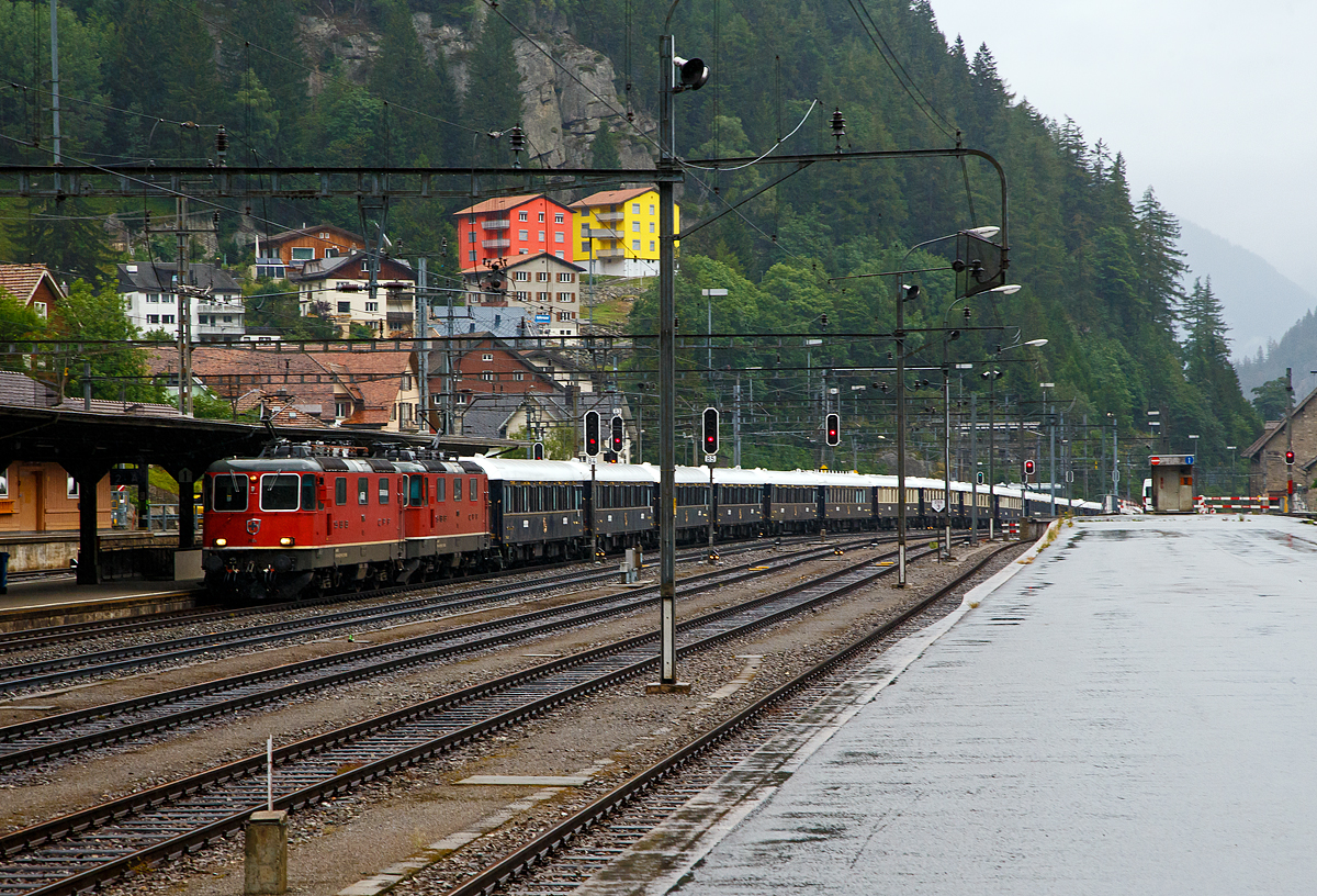 Der Orient-Express, f�r mich der Zug der Z�ge....
Die SBB Re 8/8 (Re 4/4-11194 und Re 4/4-11156) erreicht mit dem Venice Simplon-Orient-Express (VSOE) nach Venedig am 02.08.2019, leider bei Regen, den Bahnhof G�schenen. Der Orient-Express bestand aus einem 18 Wagen langen Zug (meinst historische CIWL-Wagen).

Der Venice Simplon-Orient-Express (abgek�rzt VSOE), verkehrt seit 1982. Der Luxuszug wird von der Firma Belmond Ltd. Betrieben. Der Zug ist aus historischen Wagen der Compagnie Internationale des Wagons-Lits (CIWL). Es werden Fahrten in Form von Schienenkreuzfahrten �ber verschiedene europ�ische Strecken, darunter auch die historischen Strecken des fr�heren Simplon-Orient-Express und des Orient-Express.

1977 begann die von James B. Sherwood geleitete Sea Containers Ltd. historische Wagen der CIWL und der British Pullman Company zu erwerben und aufw�ndig zu restaurieren. 

Der VSOE wurde erstmals am 28. Mai 1982 eingesetzt. Die erste angebotene Reise war die Route des Simplon-Orient-Express von London �ber Paris nach Venedig, die auch heute noch w�chentlich befahren wird. F�r die Beherbergung in Venedig kaufte die Sea Containers das Hotel Cipriani, was gleichzeitig der Einstieg der Gesellschaft ins Touristikgesch�ft war.

Betreiber war die Orient-Express Hotels Ltd., eine Tochtergesellschaft von Sea Containers, in der alle Touristikaktivit�ten eingebracht waren. Sie wurde wegen finanzieller Schieflage der Muttergesellschaft im Jahr 2005 selbst�ndig und im Juni 2014 in Belmond Ltd. umbenannt. Der Gesch�ftssitz des b�rsennotierten Unternehmens ist in Hamilton auf Bermuda. Neben dem VSOE betreibt die Belmond Ltd. verschiedene Luxusz�ge mit ehemaligen CIWL-Pullmanwagen in Gro�britannien, den Eastern and Oriental Express, sowie Hotels in 17 L�ndern. Seit Dezember 2018 geh�rt Belmond Ltd. zum franz�sischen Luxusg�terkonzern LVMH Moet Hennessy Louis Vuitton.

Die Flotte des VSOE besteht haupts�chlich aus 16 historischen ehemaligen CIWL-Wagen der Baujahre 1926 bis 1931, darunter drei Speise-, ein Bar- und 12 Schlafwagen, letztere �berwiegend vom Typ Lx der CIWL. Zus�tzlich zu diesen teilweise 1982 modernisierten ex-CIWL-Fahrzeugen f�hrt der Zug Servicewagen sowie andere, farblich angepasste Wagen. 2003–2006 wurden die kontinentalen Wagen des VSOE modernisiert und erhielten unter anderem moderne Drehgestelle von Bombardier sowie neue Klimaanlagen. Seitdem sind die Waggons f�r 160 km/h zugelassen. 
