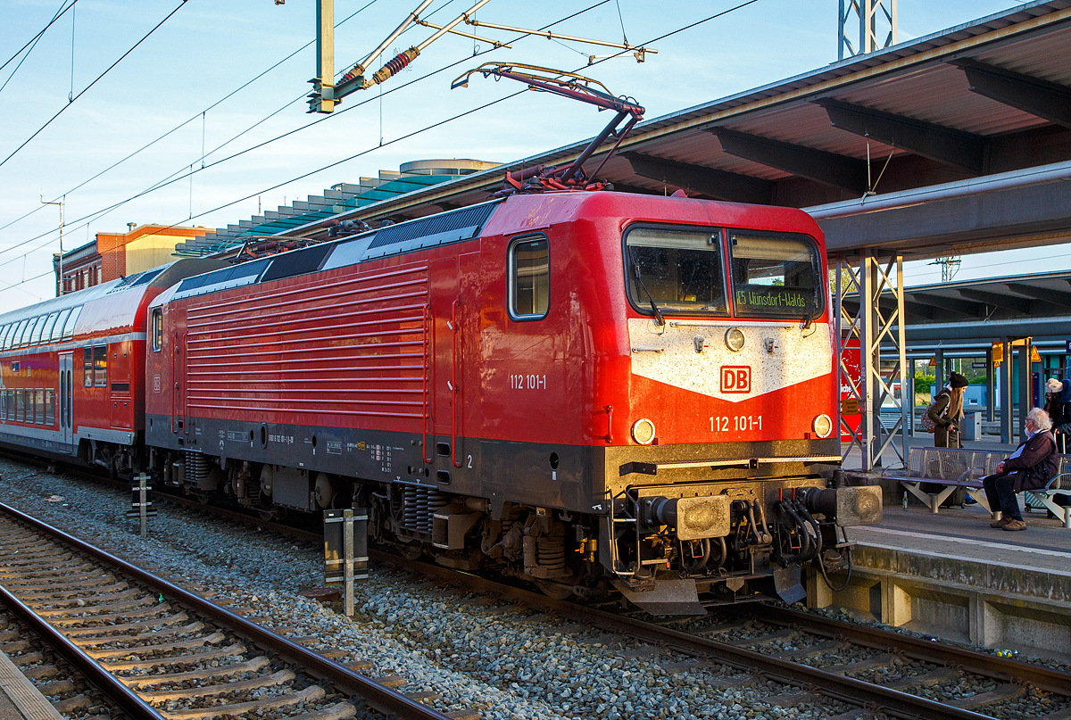Die 112 101-1 (91 80 6112 101-1 D-DB) der DB Regio Nordost steht am 14.05.2022, mit dem RE 5 (Rostock – Stralsund – Berlin – Wünsdorf-Waldstadt), im Hbf Rostock zur Abfahrt bereit.

Die Lok wurde 1992 von AEG in Hennigsdorf unter der Fabriknummer 21477 gebaut und an die Deutsche Reichsbahn als DR 112 101-1 geliefert. Aus der Hennigsdorfer Lokschmiede LEW - VEB Lokomotivbau Elektrotechnische Werke „Hans Beimler“ Hennigsdorf wurde wieder von der AEG übernommen. DB und DR bestellten jeweils 45 Lokomotiven der Baureihe 112.1. Die an die DR gelieferten Maschinen bekamen die Betriebsnummern 112 101-1 – 112 145-8, die an die DB gelieferten die 112 146-6 – 112 190-4. Nach dem Zusammenschluss der beiden deutschen Bahnen zum 01.01.1994 zur DB AG wurden aus den DR Maschinen DB, so auch die 112 101-1.
