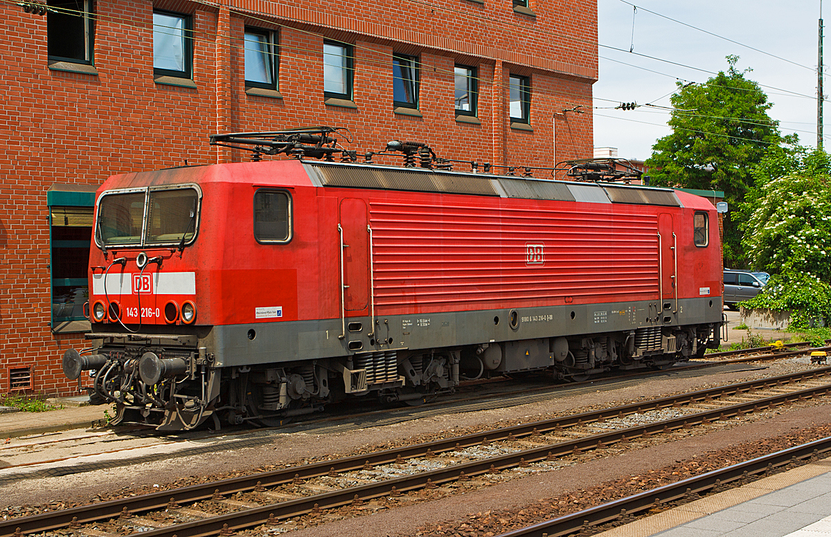 
Die 143 216-0 der DB Regio, ex DR 243 216-9, abgestellt  am 25.05.2014 beim Hbf Koblenz.

Die Lok wurde 1987 bei LEW (VEB Lokomotivbau Elektrotechnische Werke Hans Beimler Hennigsdorf) unter der Fabriknummer 18965 gebaut und als DR 243 216-9 an die Deutsche Reichsbahn geliefert, 1992 erfolgte die Umzeichnung in DR 143 216-0 und zum 01.01.1994 in DB 143 216-0. 

Ein Umbau (Einbau Notbremsüberbrückung (NBÜ) und elektropneumatischer Bremse (ep) erfolgte 2006 und 2010 die Hochrüstung auf NBÜ 2004.
Die Notbremsüberbrückung (NBÜ) dient bei Personenzügen dazu, den Zug trotz betätigter Notbremse weiterfahren zu lassen und erst an einem besser geeigneten Ort zum Stillstand zu bringen. Grund für ihre Einführung war, dass das Halten eines brennenden Zuges in einem Tunnel zu verheerenden Folgen führen kann, aber auch, dass ein Zug, der an einem schwer zugänglichen Punkt zum Stehen kommt, die Bergung erschwert. Die Notbremsüberbrückung darf vom Triebfahrzeugführer nur in besonders gekennzeichneten Streckenabschnitten angewandt werden.

Bei der NBÜ 2004 führt die Betätigung einer Notbremse allerdings zunächst nur zu einer optischen und akustischen Meldung im Führerstand. Der Triebfahrzeugführer muss diese Meldung entweder durch einen Überbrückungsbefehl oder durch eine Schnellbremsung bestätigen. Andernfalls wird die Notbremsung nach kurzer Zeit selbsttätig wirksam.

Die Lok trägt seit 2007 die NVR-Nummer  91 80 6143 216-0 D-DB und die EBA-Nummer  EBA 01C17A 216.