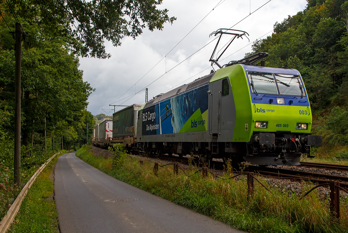 Die BLS Cargo 003 - Re 485 003-8  (91 85 4485 003-8 CH-BLSC) fährt am 26.08.2021 mit einem KLV-Zug bei Wissen (Sieg) über die Siegstrecke (KBS 460) in Richtung Köln.

Die TRAXX F140 AC1 wurde 2003 von  Bombardier in Kassel unter der Fabriknummer 33548 gebaut und an die BLS Cargo geliefert. Die Loks sind nur für die Schweiz und Deutschland zugelassen.

Die BLS Cargo AG bestellte 2002 die elektrischen Zweifrequenz-Güterloks des Typs Re 485, mit der Option über weitere 10 Stück. Die Lok sollen vor allem grenzüberschreitend im Verkehr mit Deutschland eingesetzt werden. 

Die Re 485 (TRAXX F140 AC1) sind 85 Tonnen schwer und 140 km/h schnell. Mit der installierten Leistung von 5,6 MW ist sie geeignet für den Transport schwerer Güterzüge über die Lötschberg—Simplon-Bergstrecke ebenso wie durch den Lötschberg-Basistunnel. Sie verfügt über je zwei Stromabnehmer für Deutschland und für die Schweiz und ist mit Zugsicherungssystemen beider Länder ausgerüstet.

Zusammen mit den technisch gleich ausgerüsteten DB-Cargo-Maschinen der Baureihe 185 sollen künftig - im Sinne der Kooperation der beiden Güterverkehrsunternehmen - Abläufe beschleunigt und Synergien erzielt werden.

TECHNISCHE DATEN:
Spurweite:  1.435 mm (Normalspur)
Achsformel:  Bo’Bo’
Länge über Puffer:  18.900 mm
Höhe:  4.385 mm
Breite:  2.978 mm
Drehzapfenabstand:  10.400 mm
Achsabstand im Drehgestell: 2.600 mm
Dienstmasse:  85 t
Höchstgeschwindigkeit:  140 km/h
Dauerleistung:  5.600 kW
Dauerzugkraft:  300 kN
Treibraddurchmesser:  1.250 mm
Stromsysteme:  15 kV 16,7 Hz (und 25 kV 50 Hz) Wechselstrom  
Antrieb:  Tatzlager