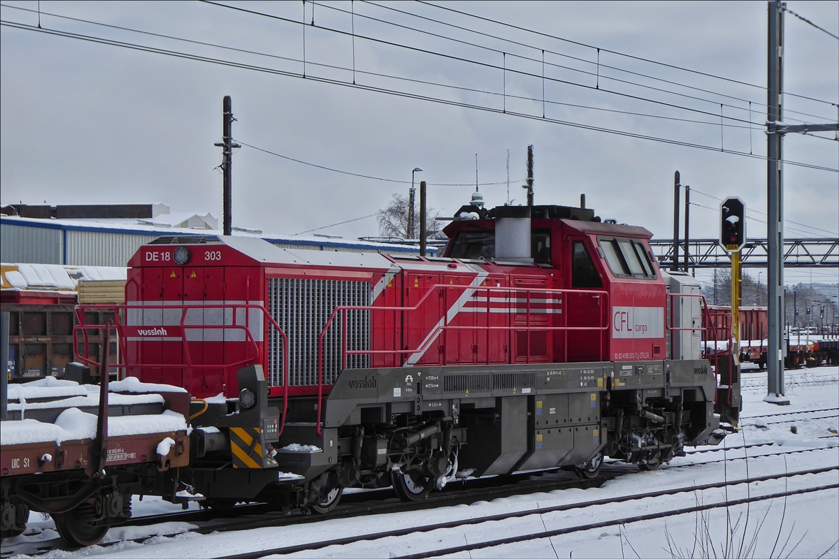 Die CFL Cargo Diesellok DE 18-303 (92 82 4185 303 – 7) steht mit einem G�terzug auf einem Nebengleis im schneebedeckten Bahnhof Belval-Universit�. 31.01.2019 (Hans)
Fahrzeugdaten: 
Hersteller: Vossloh; 
Typ: DE 18; 
Baunr. 5502182; 
Bauart: Bo’Bo‘-de; 
Baujahr  2017; 
Spurweite: 1435 mm; 
wurde am 14.12.2017 an die CFL Cargo geliefert.
