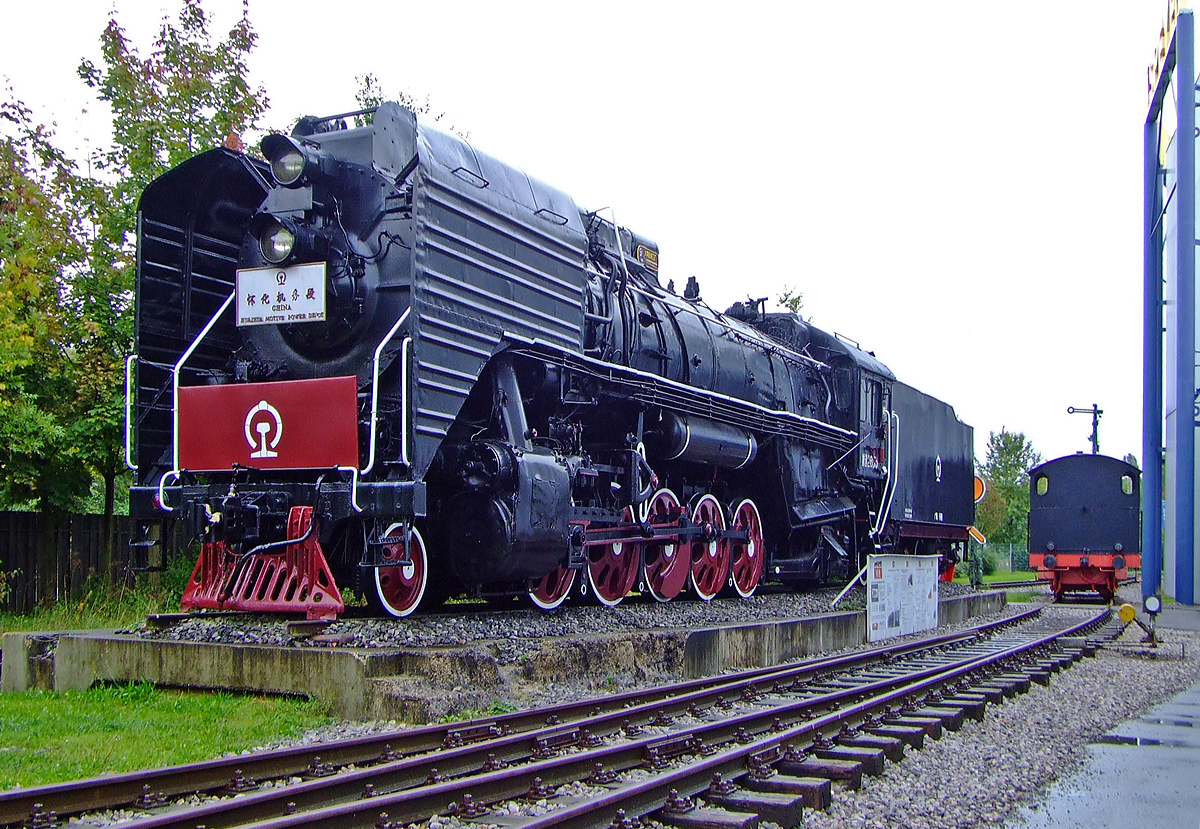 
Die chinesische 1´E1´-Güterzug-Dampflokomotiven QJ 2655 im  Technikmuseum Speyer, hier am 02.10.2010

Die Güterzuglokomotiven der Reihe QJ (Qian Jin = Fortschritt) gehen auf die sowjetische Standardlok  SŽD-Baureihe ЛВ (deutsche Transkription LW, urspr. OR18) zurück. Von diesen 1E1-Dampfloks wurden zwischen 1956 und 1988 insgesamt 4.700 Stück gebaut. Die chinesischen Konstrukteure verbesserten und modifizierten die einfach und robust gebauten Maschinen. Bei den mit Verbrennungskammer ausgerüsteten Dampfloks kann das Gewicht kurzzeitig von den Laufrädern auf die Triebräder verlagert werden, um die Reibungsmasse zu erhöhen. Sie fuhren bis 01. März 2005 im fahrplanmäßigen Einsatz noch am Jingpeng-Pass. China war das letzte Land in dem noch Dampfloks fahrplanmäßig im Einsatz waren.

Technische Daten:
Bauart: 1'E1' 
Länge über Puffer: 16.140 mm
Eigengewicht: 123 t
Leistung: 2.193 kW (ca. 3.000 PS)