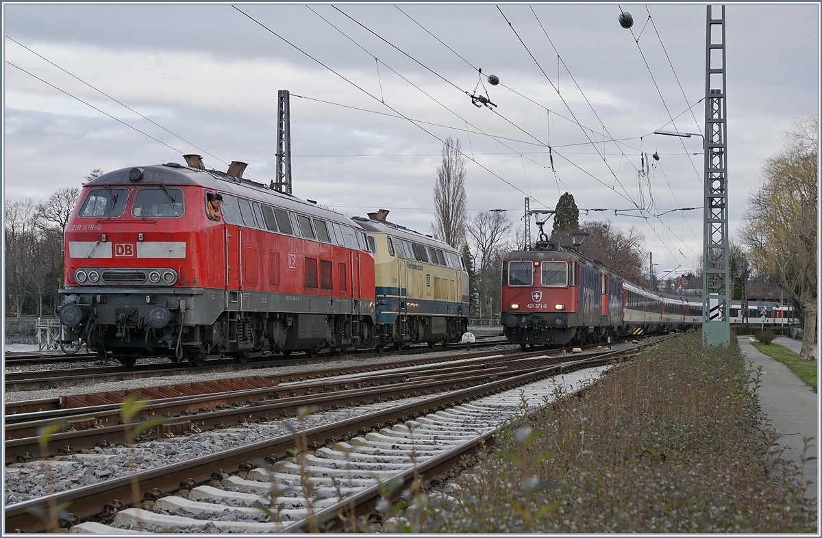 Die DB V 218 419-0 und die Westfrankenbahn 218 460-4 warten auf dem Seedamm in Lindau den nun von Zürich kommenden EC, welcher von der SBB RE 421 371-6 angeführt wird. Die zweite Re 421 läuft Umlaufbedingt mit.

16. März 2019