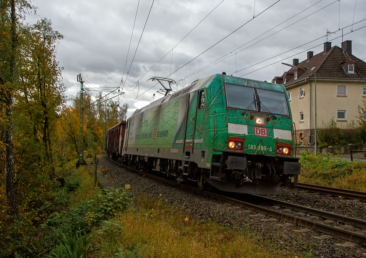 Die grüne DB Cargo 185 389-4 (91 80 6185 389-4 D-DB), mit Werbung „DB Schenker/Audi Logistik Co2-frei“, fährt am 22.10.2021 mit einem offenen Güterzug (Wagen der Gattung Eaos-x) durch Kirchen (Sieg) in Richtung Siegen. Hinweis: Ich stehe beim BÜ km 121,192.

Die TRAXX F140 AC2 wurde 2009 von Bombardier in Kassel unter der Fabriknummer 34693 gebaut. Sie hat die Zulassungen für Deutschland und Österreich.
