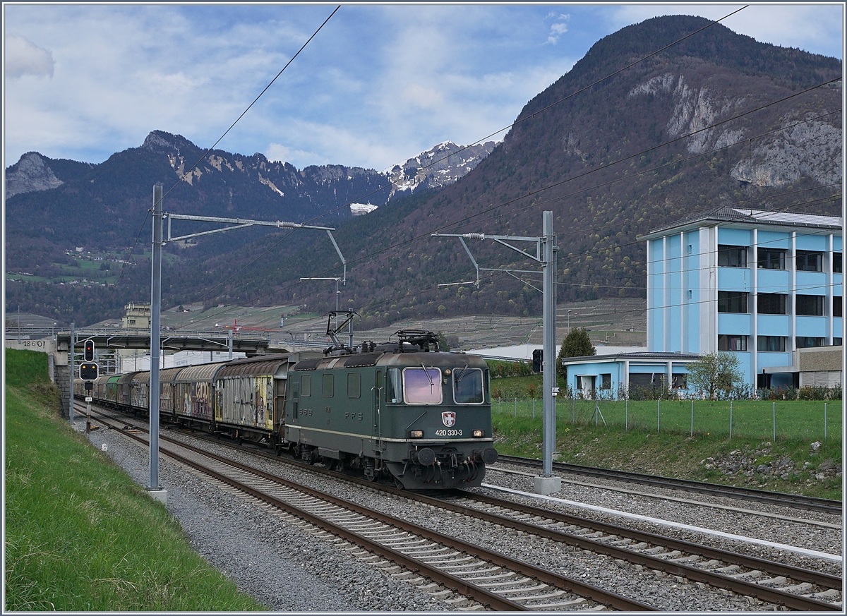Die grüne SBB Re 420 330-3 mit einem Güterzug Richtung Wallis bei der Ausfahrt in Aigle. 

12. April 2018
