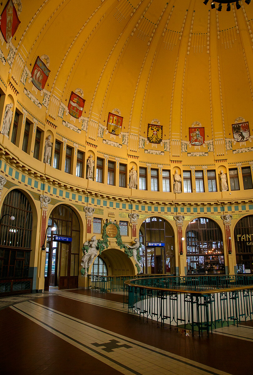 Die historische ehemalige Schalterhalle im Jugendstil vom Hauptbahnhof Prag (Praha hlavní nádraží) am 23.11.2022.

Der Bahnhof wurde im Jahr 1871 von der k.k. priv. Kaiser Franz-Josephs-Bahn (KFJB) als Endpunkt ihrer Strecke von Wien gebaut und hieß zunächst Prag Kaiser-Franz-Joseph-Bahnhof (tschechisch: Nádraží císaře Františka Josefa(. Das erste Gebäude wurde von den Architekten Vojtech Ignaz Ullmann und Anton Viktor Barvitius entworfen. In den Jahren 1901–1909 wurden, neben den technischen Erweiterungen, nach dem Entwurf des bedeutenden Architekten Josef Fanta das bis heute genutzte Aufnahmegebäude im Jugendstil gebaut.

Nach dem Ersten Weltkrieg wurde der Bahnhof nach dem amerikanischen Präsidenten Woodrow Wilson in Wilson-Bahnhof (Wilsonovo nádraží) umbenannt. Unter der deutschen Besatzung (1939–1945) hieß er Hlavní nádraží (Hauptbahnhof). Nach dem Zweiten Weltkrieg hieß er wieder Wilson-Bahnhof, allerdings nur bis zur nochmaligen Rückumbenennung in Hauptbahnhof 1953. 