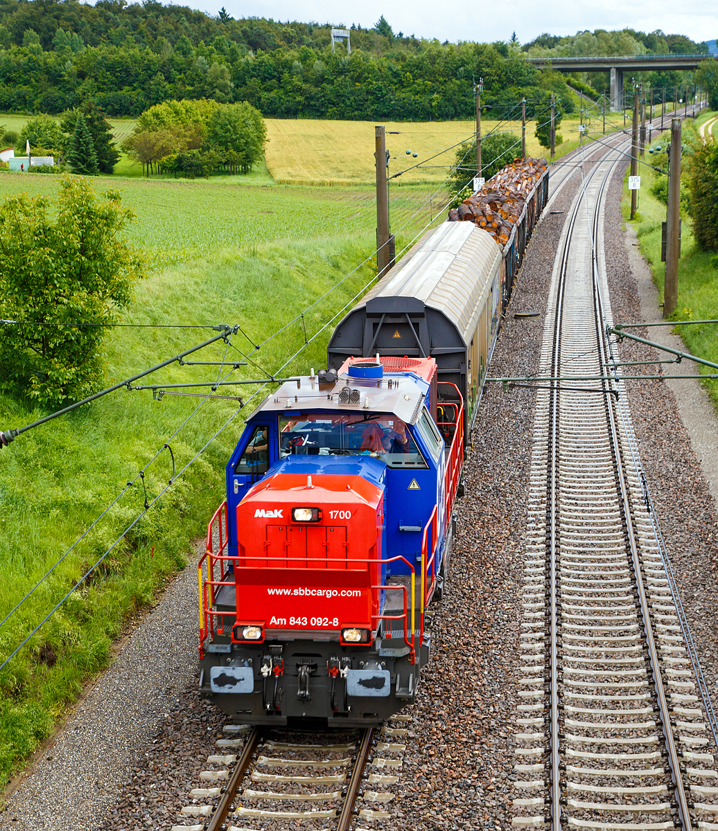 
Die SBB Cargo Am 843 092-8 (eine modifizierte Vossloh MaK 1700) f�hrt am 17.06.2016 mit einem kurzen G�terzug durch Bietingen in Richtung Schaffhausen. 

Einen lieben Gru� an den freundlichen Lokf�hrer zur�ck.

Die Lok wurde 2005 von Vossloh in Kiel unter der Fabriknummer 1001440 gebaut und an die SBB Cargo AG in Basel geliefert. Sie geh�rt zu den letzten f�nf Loks der Serie an die SBB Cargo, diese f�nf Maschinen (Am 843 091 bis 095) sind zus�tzlich mit der deutschen Zugsicherung Indusi ausger�stet worden und haben einen zweiten F�hrerstand auf der rechten Seite. 

Die SBB Am 843 ist eine moderne Rangier- und G�terzugslokomotive der Schweizerischen Bundesbahnen (SBB). Sie ersetzt �ltere Rangierlokomotiven wie die SBB Bm 4/4 und SBB Bm 6/6. Eingesetzt wird die Am 843 von der Division Infrastruktur (843 001ff), der Division Personenverkehr (041ff) und von SBB Cargo (050ff). Die Division Infrastruktur verwendet die Am 843 vor allem in den grossen Rangierbahnh�fen, Personenverkehr in Basel und Chiasso und bei SBB Cargo dient sie vor allem f�r Zustellfahrten im Nahg�terverkehr.

Die Am 843 verf�gt �ber einen Mikropartikelfilter und gilt als eine der saubersten Diesellokomotiven. Die Filteranlage verhindert, dass 95 % der Russpartikel in die Umwelt abgegeben werden. Die Am 843 basiert auf den dieselhydraulischen Standardlokomotiven des Typs G 1700-2 BB des Kieler Schienenfahrzeugherstellers Vossloh, ist aber im Gegensatz zur Standard-Version auf den in der Schweiz �blichen Linksverkehr ausgelegt.

Anfang der 2000ter musste eine neue Lokomotive angeschafft werden, welche allen Anforderungen gerecht wurde. So musste die Lok �ber hervorragende Langsam Fahreigenschaften verf�gen um im Verschubdienst eingesetzt werden zu k�nnen. Die SBB-Cargo wollte aber auch im Nahbereich Zustellfahrten machen, was eine H�chstgeschwindigkeit von 100 km/h erfordernde und gute Leistung. Schlie�lich fiel die Wahl auf die MaK 1700 BB, welches bei Vossloh in Kiel entstehen sollte. Vossloh entstand aus der ehemaligen und bekannten Unternehmen Maschinenfabrik Kiel (MaK). Dies war die erste gr��ere Serie die der Kieler Lokomotivbau in die Schweiz verkaufen konnte. Noch bei der letzten Ausschreibung haben die Kieler gegen das Konsortium um Alstom verloren. Ebenfalls eine Neuheit war, dass die SBB erstmals eine gr��ere Anzahl dieselhydraulischer Lokomotiven anschafften, nachdem bei der Am 841 noch einer dieselelektrischen Lokomotive der Vorzug gew�hrt wurde.

Der Lokrahmen besteht aus Walztr�gern und massiven Blechen, welche in Schwei�konstruktion miteinander verbunden wurden. Dadurch entsteht ein stabiler und robuster Grundaufbau, welcher der Lok die notwendigen Festigkeiten verleiht. Im Lokrahmen wurde eine so genannte Umweltwanne montiert, welche aus dem Fahrmotor austretenden Fl�ssigkeiten (Mineral�len und Wasseremulsionen) auff�ngt, diese k�nnen mit Hilfe eines Ablasshahnes entleert und fachm�nnisch entsorgt werden.

Der vordere l�ngere Vorbau beinhaltet neben dem Dieselmotor auch die notwendige K�hlanlage und das Antriebsgetriebe. Der k�rzere hintere Vorbau enth�lt neben der Druckluftanlage auch die elektrischen Komponenten wie die Batterieladung.

Zwischen den beiden Vorbauten befindet sich das Mittelf�hrerhaus, welches �ber die zwei diagonal gegen�berliegenden Eingangst�ren betreten werden kann. In ihm sind alle f�r den Lokf�hrer notwendigen Einbauten vorhanden. Ein F�hrersitz je Fahrpult und Fahrrichtung, welcher mit Arm- und R�ckenlehnen ausger�stet ist, erlaubt die sitzende Bedienung der Lokomotive. Dieser F�hrersitz ist drehbar gelagert und kann zusammengeklappt und unter den F�hrertisch verschoben werden. Dadurch ist auch die stehende Bedienung der Lokomotive ohne Behinderung m�glich. Zur Entlastung der F��e sind auch verstellbare Fu�st�tzen montiert. Der Fu�boden ist mit einem Profilgummibelag belegt worden, der eine einfache Reinigung und dennoch einen guten Stand erlaubt.

Angetrieben wird die Lokomotive von einem 12-Zylinder-4Takt-Dieselmotor vom Typ Caterpillar 3512 B DI-TA-SCAC, dieser erbringt mit Hilfe der beiden Abgasturbolader und der Ladeluftk�hlung eine maximale Leistung von 1.500 KW (2.040 PS). Seine h�chste Drehzahl betr�gt 1.800 U/min. Er wird mit Hilfe eines elektrischen Anlassers gestartet und ist elektronisch geregelt. Dadurch ist es m�glich, den Motor bestm�glich im optimalen Leistungsbereich zu betreiben. Sein Gewicht betr�gt mit 322 Liter Schmier�l und 134 Liter K�hlwasser 7.700 kg.

Die vom Dieselmotor erzeugte Leistung wird mittels einer Gelenkwelle auf das hydrodynamische Getriebe (Turbowendegetriebe), vom Typ Voith L5r4zseU2, �bertragen. Das Getriebe hat eine maximale Leistung von 1.400 kW. Es beschr�nkt somit die Leistung der Lokomotive und verhindert zugleich, dass der Fahrmotor �berlastet werden kann. Seine maximale Drehzahl ist gleich gro�, wie jene des Fahrmotors. 

Das Turbowendegetriebe besitzt f�r jede Fahrrichtung zwei Drehmomentwandler. Dem eigentlichen Wandlergetriebe ist eine mechanische Getriebe nachgeschaltet, das eine niedrige f�r den Rangierbetrieb bestimmte Schaltung und eine h�here f�r den Streckenbetrieb bestimmte Schaltung zur Verf�gung zu stellen. Diese Umschaltung darf jedoch erst im Stillstand erfolgen.

Die Achsen in den Drehgestellen werden �ber Gelenkwellen vom Turbowendegetriebe angetrieben. Die �bertragung auf die Achsen erfolgt mit Hilfe von Stirnradgetrieben mit Kegelradvorgelege.

Technische Daten:
Spurweite: 1.435 mm (Normalspur)
Achsformel: B'B'
L�nge �ber Puffer: 15.200 mm
H�he: 4.220 mm
Breite: 3.080 mm
Drehzapfenabstand: 7.700 mm
Achsstand im Drehgestell: 2.400 mm
Dienstgewicht:  80 t
H�chstgeschwindigkeit: 100 km/h (40 km im Rangiergang)
Installierte Leistung: 1.500 kW (2.040 PS)
Anfahrzugkraft:  249 kN
Treibraddurchmesser:  1.000 mm
Motorentyp:  Caterpillar 3512B DI-TA-SCAC
Nenndrehzahl: 1.800/min
Kleinster bef. Halbmesser:  60 m
Tankinhalt: 3.500 l