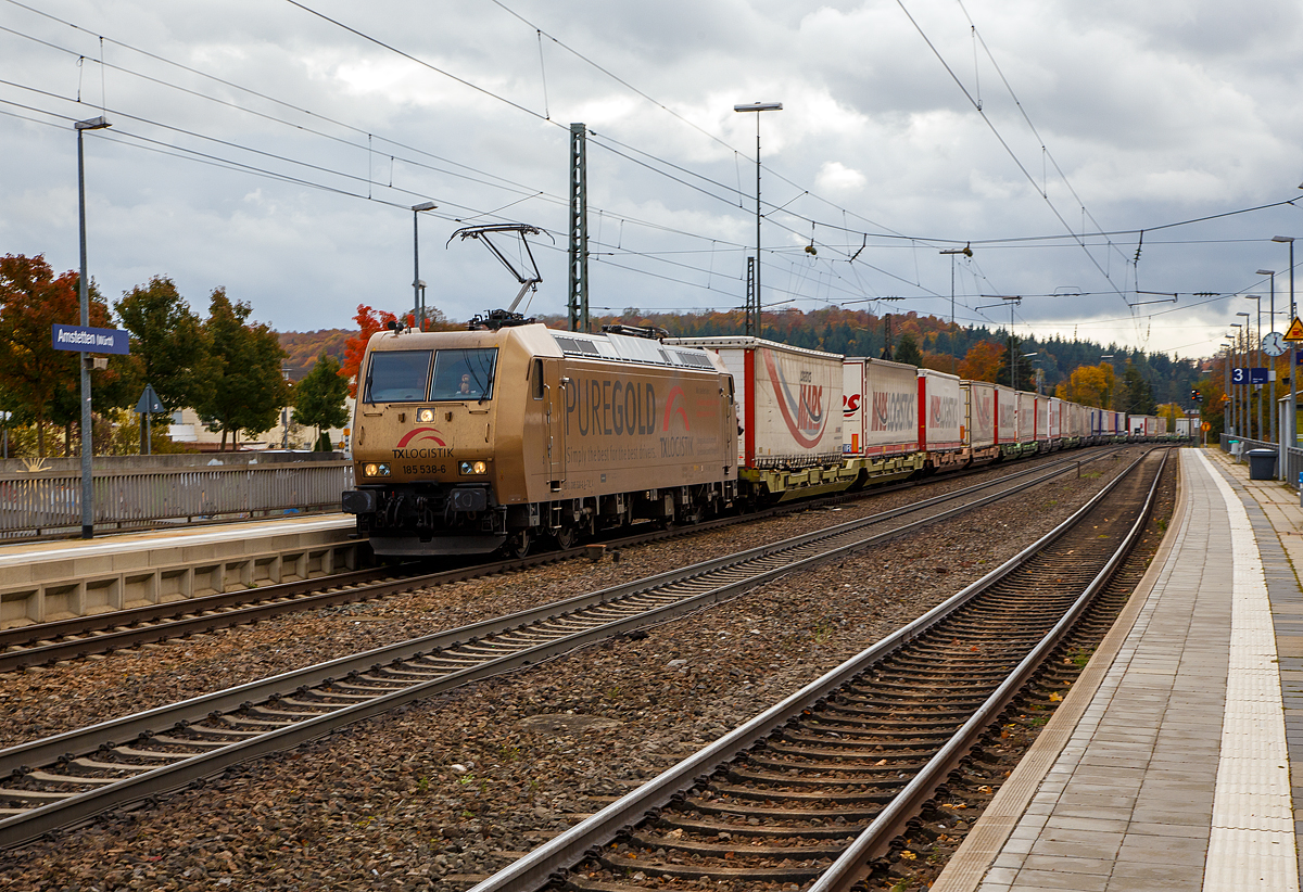 Die TX Logistik 185 538-6 (93 81 0185 538-6 A-TXLA, ex 91 80 6185 538-6 D-TXL) f�hrt am 26.10.2021 mit einem langen KLV-Zug durch den Bahnhof Amstetten (W�rtt) in Richtung Stuttgart. Gleich geht es die ber�hmte Geislinger Steige hinab. 

Nochmal einen liebe Gru� an den netten Lokf�hrer zur�ck, der mich hier mit Lichthupe gr��te.

Die TRAXX F140 AC wurde 2004 bei Bombardier in Kassel unter der Fabriknummer 33657 gebaut. Sie hat die Zulassungen f�r Deutschland und �sterreich. Die Lok tr�gt die Werbung PUREGOLD f�r die TX Logistik.