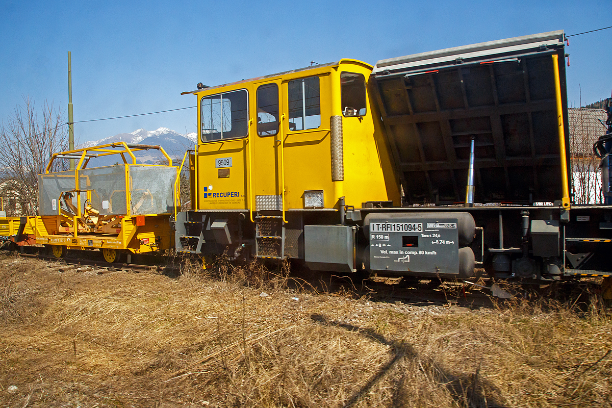 Ein ehemaliger SBB Baudiensttraktor vom Typ Tm III (Autocarrelli con gru Tm III) IT-RFI 151094-5 der Italienischen Firma Recuperi srl., ex SBB Tm III 9509 (Ausführung mit Ladebühne und Kran) ist am 27.03.2022 bei Bruneck / Brunico abgestellt. Aufnahme aus fahrenden Zug durch die Scheibe.

Der Tm III wurde 1982 von RACO (Typ 225 SV4 H) unter der Fabriknummer 1878 gebaut uns als Tm III 9509 an die SBB geliefert.
