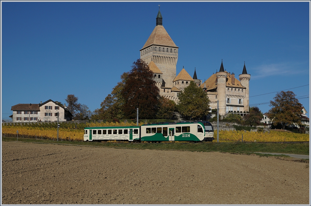 Ein zweiteiliger BAM Regionalzug, bestehend aus einem neuen SURF Be 4/4 und einen  �lteren  Bt, auf der Fahrt nach Biere vor der Kulisse des Ch�teau de Vufflens.
17. Okt. 2017