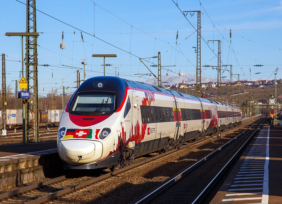 Eine sehr angenehme �berraschung fuhr mir vor die Linse...
Der SBB RABe 503 022 „Johann Wolfgang von Goethe“  (NVR-Nr. 93 85 0 503 022-2 CH-SBB) im Drei-L�nder-Design bzw. Drei-Bahnen- Design (SBB / DB / FS) f�hrt am 29.12.2017, als ECE 151 (Frankfurt - Basel – Lugano – Mailand), durch den Bahnhof Weil am Rhein in Richtung Basel. Weit im Hintergrund der schneebedeckte 1.165 m hohe Blauen (auch Hochblauen genannt), Hausberg des Markgr�flerlands.

Seit dem Fahrplanwechsel zum 10. Dezember 2017 hat Frankfurt am Main, erstmals wieder nach �ber zehn Jahren einen Direktzug nach Mailand. Doch es ist kein ICE der Deutschen Bahn der die Verbindung erm�glicht, sondern ein Hochgeschwindigkeitszug der SBB der ETR 610 (italienisch: ElettroTreno Rapido).  Der Frankfurt-Mailand-Express wird von der SBB nur als Verl�ngerung der Verbindung Mailand–Basel bis Frankfurt realisiert.

F�r Deutschlands Schienennetz wurde daf�r sogar eine neue Zuggattung aus der Taufe gehoben: der Euro-City-Express (ECE).

Der ETR 610 (SBB-Bezeichnung RABe 503) ist die Drei-System-Variante des ETR 600 f�r den Personenverkehr der Schweizerischen Bundesbahnen zwischen der Schweiz und Italien, sowie nun auch Deutschland. Der Hochgeschwindigkeitszug wird von Alstom in Italien gebaut. Das Design stammt vom dem italienischen Stardesigner Giorgio Giugiaro.

Vier der sieben Wagen eines Zuges werden angetrieben. Der Zug f�hrt bis zu 250 Kilometer pro Stunde.

Wegen des L�tschberg- und Gotthard-Basistunnels waren verschiedene beh�rdliche Auflagen zu erf�llen. So sind die Z�ge mit Rauchmeldern ausger�stet und der Zug weist eine Notlauff�higkeit von 15 Minuten auf, die Traktionsausr�stung muss also 15 Minuten nach einem Brandausbruch funktionsf�hig bleiben. 

Die Z�ge der 2. und 3. Serie sind gegen�ber der ersten Serie optimiert und von Beginn weg f�r den Einsatz im Gotthard-Basistunnel eingerichtet. Die Auslieferung begann 2014, bis Anfang M�rz 2015 war bereits die H�lfte der Z�ge im Betriebseinsatz.

TECHNISCHE DATEN:
Einsatzland:  Italien, Schweiz, Deutschland
Hersteller:	Alstom
Anzahl der Z�ge:14 Z�ge (1.Serie), 8 (2.Serie) und 4 (3.Serie)
Baujahre:	2005 - 2017
Spurweite:	1.435 mm 
Achsformel: (1A)'(A1)' + (1A)'(A1)' + 2'2' + 2'2' + 2'2 + (1A)'(A1)' + (1A)'(A1)'
L�nge �ber Kupplung:  187,4 m
Leergewicht:  450 t
H�chstgeschwindigkeit: 250 km/h
Anzahl der Fahrmotoren: 8
Antriebsleistung des Zuges:	5.500 kW
Beschleunigung des Zuges:	0,48 m/s�
Anfahrzugkraft:	228 kN
Neigetechnik: bis zu 8� 
Kleinster befahrbarer Gleisbogenhalbmesser: 250 m
Stromsysteme:	3 kV Gleichstrom, 25 kV 50 Hz Wechselstrom und 15 kV 16,7 Hz Wechselstrom
Stromabnehmerausr�stung: zwei 3/1,5 kV DC-SA mit 1.950 mm Breite auf den Wagen 4 und 5 f�r das Netz RFI (Italien), zwei 15 kV 16,7 Hz AC-SA mit 1.950 mm Breite f�r das Netz DB auf den Wagen 3 und 6 und zwei 15 kV / 25 kV 16,7 bzw. 50 Hz AC-SA mit 1.450 mm Breite f�r das Netz SBB und Italien auf den Wagen 4 und 5
