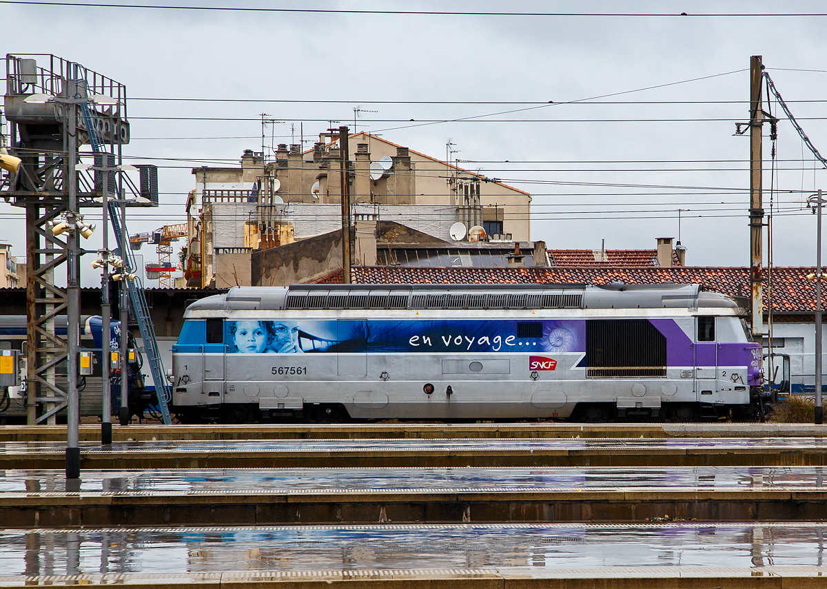 F�r mich auch eine der sch�nsten franz�sischen Dieselloks die SNCF BB 67400: Hier die BB (5)67561 f�hrt am 25.03.2015 mit eine Nahverkehrszug vom Bahnhof Marseille Saint-Charles, hier bei Regen �ber die Bahnsteige hinweg fotografiert.