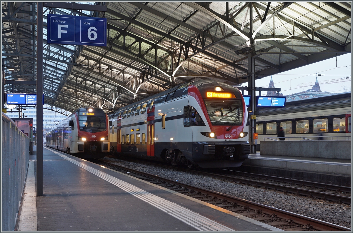 In Lausanne steht der SBB RABe 511 103 als RE nach Annemasse und der SBB RABe 523 104 als S1 nach Grandson. An diesem Wochenende (wie auch am vorhergehenden) wurden infolge von Weichenerneuerungen in Lausanne weitreichende Fahrplanänderungen nötig, da in Lausanne nur noch die Gleise 1 (von und nach Bern) sowie 7 und 8 (von und nach dem Wallis) durchgehend befahrbar waren. Alle anderen Gleise konnte Baustellenbedingt nur als Kopfgleise genutzt werden.

21. Nov. 2021