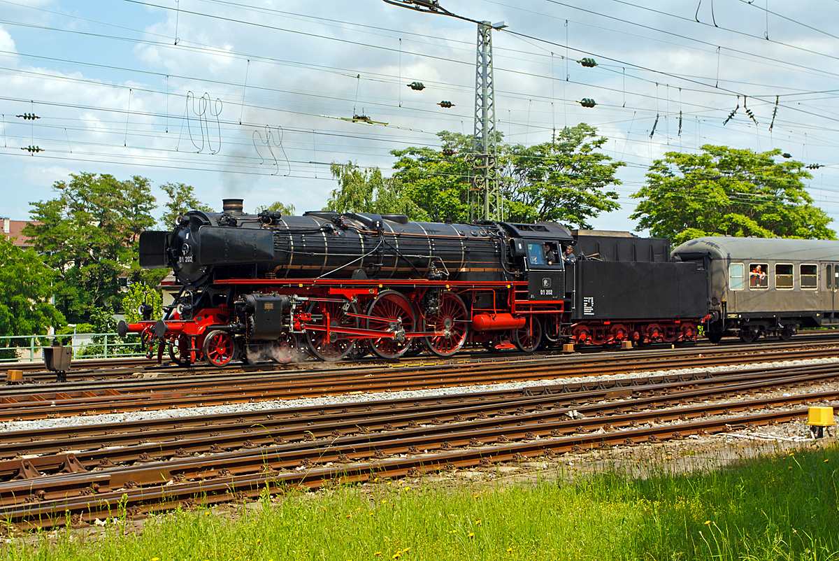 Ist sie nicht einfach eine Schönheit......
Die Schnellzug-Dampflokomotive 01 202 (90 85 0001 202-0 CH-VPAC) vom Verein Pacific 01 202, ex DB 001 202-1, ex DB 01 202, ....

Hier fährt sie am 31.05.2014 mit ihren Personenzug beim Dampfspektakel 2014 gleich in den Hauptbahnhof Neustadt an der Weinstraße ein. 

Die Lok wurde 1937 von Henschel & Sohn, in Kassel unter der Fabriknummer 23254 gebaut und wurde an die Deutsche Reichsbahn als DR 01 202 geliefert. Der Kessel wurde 1935 bei Henschel und Sohn in Kassel unter der Fabriknummer 22569 gefertigt, und ist heute noch immer Bestandteil der Lok. Nach Kriegsende kam die Maschine zur Deutschen Bundesbahn und wurde vorwiegend im süddeutschen Raum eingesetzt. Ihre letzten Einsätze erlebte die 01 202 vom BW (Betriebswerk) Hof aus, wo sie auch oft auf der schiefen Ebene anzutreffen war. Die Ausmusterung bei der DB erfolgte 1973 und 1975 wurde sie an die Eurovapor in die Schweiz verkauft. 

Die Dampflokomotiven der Baureihe 01.0 waren Schlepptenderlokomotiven der Deutschen Reichsbahn für den schweren Schnellzugdienst. Sie waren die ersten in Serie gebauten Einheitsdampflokomotiven mit der Achsfolge 2´C1´ (auch Pacific genannt). 

Die Firmen AEG und Borsig, welche die Haupthersteller dieser Maschinen waren, sowie Henschel, Hohenzollern, Krupp und BMAG vormals Schwartzkopff lieferten zwischen 1926 und 1938 insgesamt 231 Exemplare dieser Einheitslokomotive für den schnellen Reisezugverkehr an die Deutsche Reichsbahn. Mit einer Zughakenleistung von 1.850 PSe bei 60 km/h war die Baureihe die bis dahin stärkste deutsche Schnellzuglokomotivbauart, der Kohlenverbrauch von niedrigen 1,17 kg/PSe*h lag gleichauf mit der bayerischen S 3/6 und damit ebenfalls im Spitzenbereich deutscher Lokomotiven.

Zunächst wurden zu Vergleichszwecken zehn Maschinen dieser Baureihe mit Zweizylindertriebwerk sowie zehn Maschinen der Schwester-Baureihe 02 mit Vierzylinderverbundtriebwerk gebaut und ausgiebigen Mess- und Erprobungsfahrten unterzogen. Die sehr kontrovers und leidenschaftlich diskutierte Entscheidung fiel schließlich zugunsten des in der Wartung einfacheren Zweizylindertriebwerks, das allerdings hinsichtlich der Brennstoffverwertung und der Leistungsfähigkeit etwas hinter dem Vierzylinderverbundtriebwerk zurückstand. (Darüber hinaus waren bei der Konstruktion des Vierzylinderverbundtriebwerks Fehler gemacht worden.) 

Die Lokomotiven der Baureihe 01 standen bei der Deutschen Bundesbahn bis zum Jahre 1973 im Einsatz. Die letzten Expemplare waren ab Ende der 60er Jahre allesamt beim BW Hof in Oberfranken beheimatet. Die Einsätze der 01 über die bekannte Steilstrecke Schiefe Ebene erreichten während des zu Ende gehenden Dampflokbetriebes der Bundesbahn Kultstatus bei vielen Eisenbahnfreunden, die Schiefe Ebene wurde zur Pilgerstätte für Fotografen und Dampflokenthusiasten aus aller Welt. Im Juni 1973 wurden schließlich die letzten acht betriebsfähigen Maschinen nach zahlreichen Abschiedsfahrten und einer Parade vor dem Hofer Lokschuppen außer Dienst gestellt.

Bei der Deutschen Reichsbahn war diese Baureihe, sogar weitgehend im Ursprungszustand mit den großen Wagnerblechen, noch bis Anfang der 1980er Jahre im Dienst. Legendär waren in den letzten Jahren die Einsätze vor den D-Zügen auf der Strecke Berlin - Dresden bis zum Herbst 1977. Erst mit dem Aufkommen der sowjetischen Großdiesellokomotiven der damaligen Baureihe 132 konnten die inzwischen fast 50 Jahre alten Schnellzuglokomotiven der Baureihe 01 in der DDR aus dem Plandienst verdrängt werden.

TECHNISCHE DATEN: 
Ausmusterung:  1982
Bauart:  2´C1´ h2 
Gattung:  S 36.20 (Schweiz A 3/6)
Spurweite:  1435 mm (Normalspur)
Länge über Puffer:  23.940 mm
Höhe:  4550 mm
Dienstmasse:  108,9 t
Gewicht Lok und Tender: 169 t
Reibungsmasse:  59,2 t
Radsatzfahrmasse:  20,2 t
Höchstgeschwindigkeit:  vorwärts 130 km/h
rückwärts 50 (80 km/h mit Sonderzulassung)
Indizierte Leistung:  1.648 kW (ca. 2.240 PS)
Kuppelraddurchmesser:  2.000 mm
Treibraddurchmesser:  2.000 mm
Laufraddurchmesser vorn: 1.000 mm 
Laufraddurchmesser hinten:  1.250 mm
Steuerungsart:  Heusingersteuerung mit Hängeeisen
Zylinderanzahl: 2
Zylinderdurchmesser:  600 mm 
Kolbenhub:  660 mm
Kesselüberdruck:  16 bar
Anzahl der Heizrohre:  107 
Anzahl der Rauchrohre: 70
Heizrohrlänge: 6800 mm
Rostfläche:  4,32 m² 
Strahlungsheizfläche:  17 m²
Überhitzerfläche:  85,00 m² 
Verdampfungsheizfläche: 247,15 m² 
Tender:  2' 2 T 34
Wasservorrat:  34,0 m³
Brennstoffvorrat:  10,0 t Steinkohle
Zugheizung:  Dampf