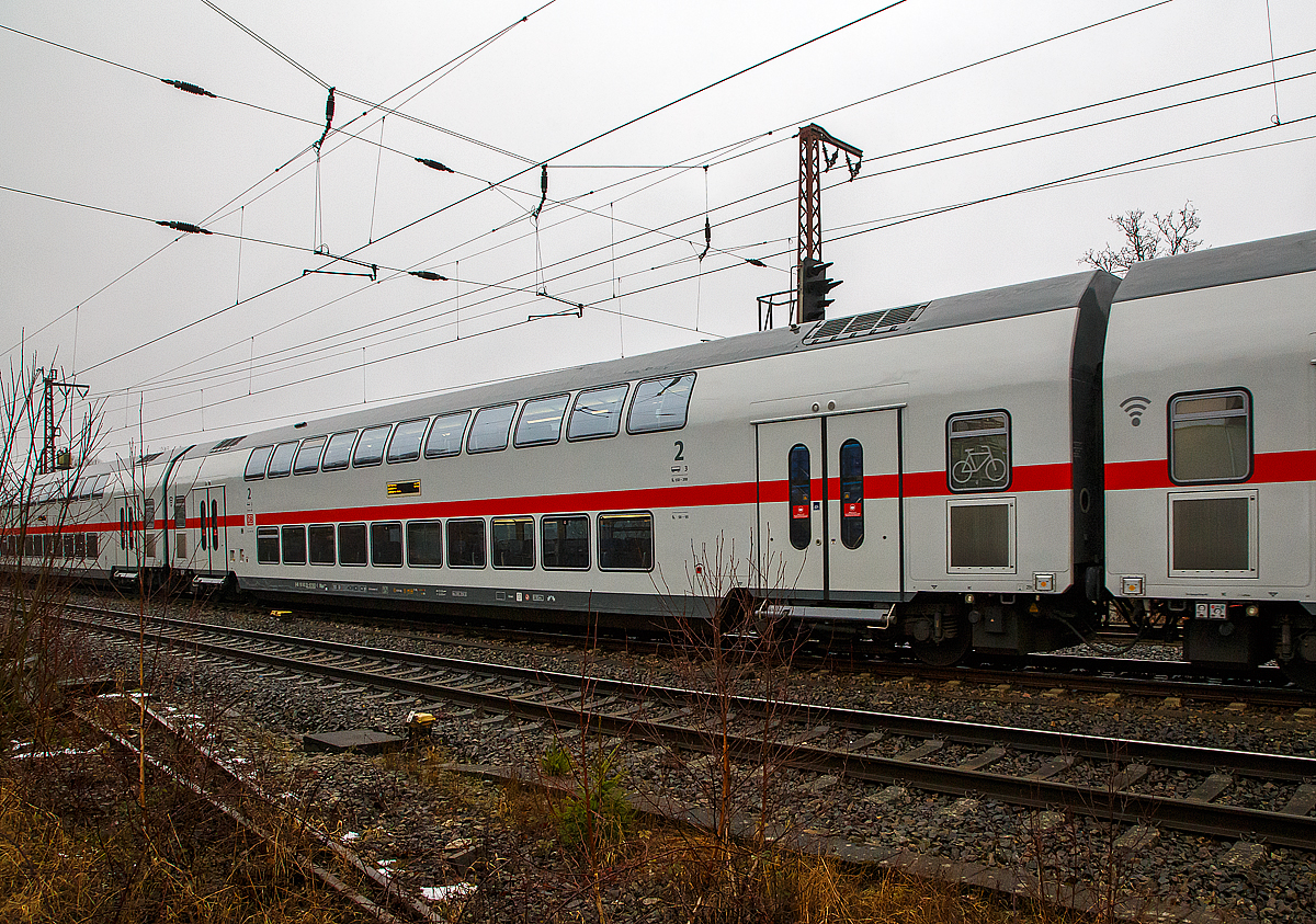Klimatisierter 2. Klasse IC2-Doppelstock- Reisezugwagen (Twindexx Vario, Mittelwagen), D-DB 50 80 26-81 582-1 DBpza 682.4 der DB Fernverkehr AG, am 12.12.2021 am Zugschluss des IC 2228 (Wagen 3), der IC 2 Zuggarnitur 4890, bei einer Zugdurchfahrt in Ruderdorf (Kr. Siegen). 

Der Wagen wurde 2018 von Bombardier G�rlitz gebaut.

TECHNISCHE DATEN: 
Gattung/Bauart: DBpza 682.4
Spurweite: 1.435 mm
L�nge �ber Puffer: 26.800 mm
Wagenkastenl�nge: 26 400 mm
Wagenkastenbreite: 2.784 mm
H�he �ber Schienenoberkante: 4.632 mm
Drehzapfenabstand: 20.000 mm
Achsstand im Drehgestell: 2 500 mm
Drehgestellbauart:  G�rlitz IX
Leergewicht:  54 t
H�chstgeschwindigkeit: 160 km/h (optional 189 km/h)
Sitzpl�tze: 113 in der 2. Klasse
Toiletten: 2, geschlossenes System
Einstieg: Hoch

DB Fernverkehr setzt seit dem 12. Dezember 2015 aus Doppelstockwagen gebildete Intercity-Z�ge unter der Bezeichnung Intercity 2 (IC2) ein. Eine Zugeinheit besteht aus je vier Doppelstock-Mittelwagen, einem Doppelstock-Steuerwagen und einer auf 160 km/h ausgelegten Lokomotive Bombardier TRAXX P160 AC2 (DB 146.5) oder TRAXX P160 AC3 (DB 147.5). Die Doppelstock-Wagen sind f�r eine H�chstgeschwindigkeit von 189 km/h vorgesehen, doch werden die Z�ge wegen der dazu erforderlichen gesonderten Zulassungsprozedur (mit noch zu bestellenden Lokomotiven der Baureihe Bombardier TRAXX P189 AC) auf l�ngere Sicht nur f�r eine Geschwindigkeit von 160 km/h zugelassen sein.

Durch die Beschaffung der Doppelstock-Intercitys sollten vordringlich Fahrzeugkapazit�ten geschaffen werden, um die Fahrzeugreserve des DB-Fernverkehrs zu vergr��ern. 

Die Z�ge verf�gen �ber 468 Sitzpl�tze, davon 70 in der ersten Klasse. Ein Bistro oder Restaurant ist nicht vorhanden, stattdessen erfolgt auf einzelnen Streckenabschnitten eine Bewirtung am Platz. Unter dem Namen IC Caf�-Team bieten Mitarbeiter von LSG Sky Chefs den Reisenden Kalt- und Hei�getr�nke, Snacks sowie Backwaren an. Die Z�ge verf�gen unter anderem �ber Handyverst�rker und eine fahrzeuggebundene Rollstuhlrampe. Eine Intercity-2-Garnitur besteht aus einem Steuerwagen mit Pl�tzen der zweiten Klasse, drei Wagen zweiter und einem erster Klasse, der mit der Lokomotive gekuppelt wird. Bei den Mittelwagen befinden sich die T�ren �ber den Drehgestellen (sogenannter Hochflureinstieg), sodass sowohl Unter- als auch Oberstock nur durch Treppen erreichbar sind. Der Unterstock der Steuerwagen ist durch Niederflureinstiege zwischen den Drehgestellen barrierefrei erreichbar und mit Rollstuhl- sowie Fahrradstellpl�tzen und einer barrierefreien Toilette ausgestattet. Der Oberstock ist nicht barrierefrei und wird im Steuerwagen �ber zwei Treppen erreicht.