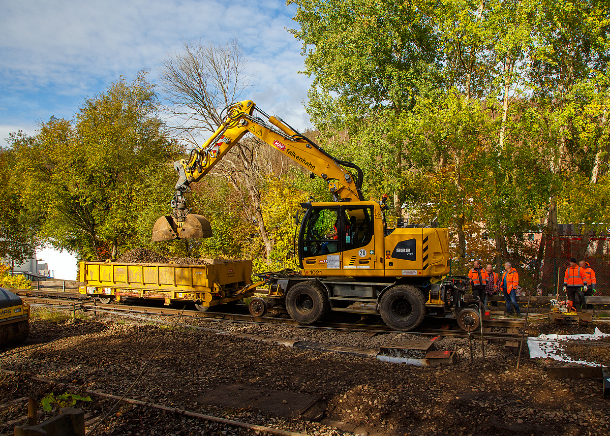 
Liebherr Zweiwegebagger A 922 Rail Litronic mit Abstützpratzen, Kleinwagen Nr. D-KAF 99 80 9903 660 -5, mit abgehangenen Gleisbauanhänger A.P.E.L. T5025 und aufgesetzter Mulde, Kleinwagen Nr. D-KAF 99 80 9550 004-2, der KAF Falkenhahn Bau AG (Kreuztal) am 24.10.2020 im Einsatz in Herdorf. Hier wird gerade ein neues Schotterbett für die neue Weiche zum Abzweig Anschlußstelle KSW erstellt.