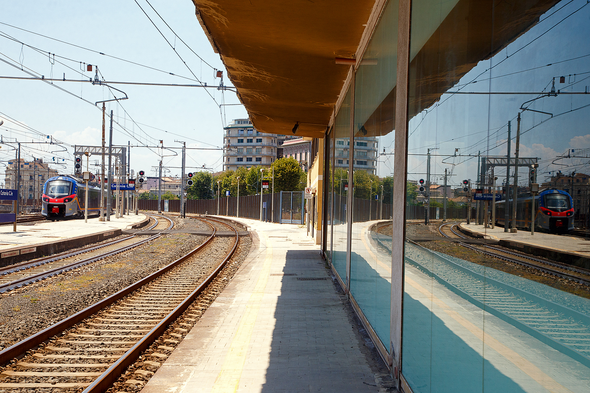 Spiellein an der Wand, wer ist der schönste im Land....
Der Trenitalia „pop“ ETR 104 083, ein vierteiliger Alstom Coradia Stream, verlässt am 20.07.2022 den Bahnhof Catania Centrale in Richtung Bicocca bzw. Syrakus (Siracusa).

Beim Alstom Coradia Stream handelt es sich um einen für den europäischen Markt entwickelten elektrischen Niederflurtriebzug für den Regional- und Intercity-Verkehr. Die Trenitalia erteilte Alstom im August 2016 einen Rahmenauftrag zur Lieferung von 150 Coradia-Zügen. Der Coradia Stream wird von der italienischen Eisenbahngesellschaft „Pop“ genannt und wird in verschiedenen italienischen Regionen eingesetzt. Er soll modular aufgebaut und damit einfacher für verschiedene Bedürfnisse anpassbar sein. Diese Lösung wird an verschiedene Konfigurationen und Kapazitätsanforderungen für den Regional- und Nahverkehr angepasst. 

Alle Coradia Stream für die Trenitalia werden in Italien in den Werken in Savigliano, Sesto San Giovanni und Bologna gefertigt.

TECHNISCHE DATEN:
Bezeichnung: ETR.103 (3-Teiler) / ETR.104 (4-Teiler)
Spurweite: 	1.435 mm (Normalspur)
Achsformel: Bo'(2')(2')Bo' (ETR 103) / Bo'(2')(2')(2')Bo' (ETR 104)
Länge über Puffer: 65,7 m (ETR 103) / 84,2 m (ETR 104)
Höchstgeschwindigkeit: 160 km/h
Leistung: 2.000 kW
Stromsystem: 3.000 V DC (=)
Sitzplätze: 	239 (ETR 103) / 321 (ETR 104)
