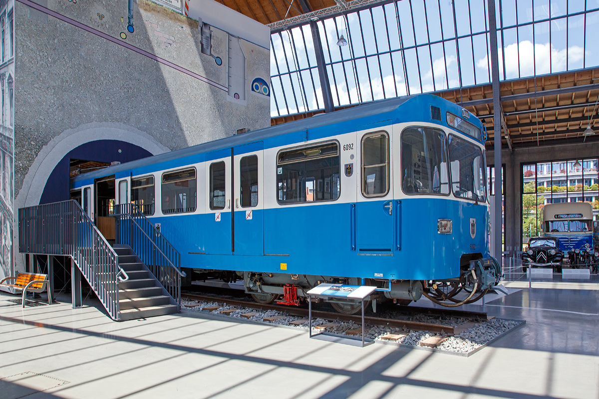 
Triebwagenh�lfte 6092 (MVG-Baureihe A 1)der ersten M�nchener U-Bahn ausgestellt im Verkehrszentrum des Deutschen Museums (am 16.06.2018) in M�nchen (Theresienh�he).

Am 22.09.1967 wurde der Wagen als eines von drei Prototypfahrzeugen f�r die neue U-Bahn in M�nchen ausgeliefert. Die U-Bahnwagen sind in Leichtbauweise mit Alu-Strangpre�profilen hergestellt worden. Damit konnten hohe Anfahrbeschleunigungen, kurze Bremswege und niedrige Energiekosten erreicht werden. Sechs breite Doppelt�ren auf jeder Seite erm�glichten einen schnellen Fahrgastwechsel. Die Waggon- und Maschinenbau GmbH Donauw�rth (WMD, heute Bombardier Transportation) lieferte insgesamt zwei Prototypen und die Waggonfabrik Josef Rathgeber einen an die damaligen Verkehrsbetriebe der Stadtwerke M�nchen, heute MVG, aus. Zur sp�teren Unterscheidung von den Serienfahrzeugen erhielten sie die Bezeichnung A1.

Die Stromversorgung erfolgte �ber seitliche Stromschienen mit 750 V Gleichstrom. Die elektrische Wagenausr�stung war einfach und robust und bot eine hohe Betriebssicherheit. Ihr geringes Gewicht erg�nzte die Leichtbauweise ideal. Es konnten 2-, 4- und 6 Wagenz�ge aneinander gekuppelt werden. Ein Linienleiter zwischen den Gleisen erm�glichte ein weitgehend automatisches Fahren der Z�ge mit Zielbremsung am Bahnsteig.

Nach erfolgreicher Erprobung der Doppeltriebwagen 6091/7091, 6092/7092 und 6093/7093 erfolgte ab 1970 die Serienauslieferung. Neben den beiden bestehenden Herstellern beteiligten sich zudem MAN sowie O&K am Bau der Fahrzeuge.

Der Wagen 6092 wurde am 28.12.1995 nach 28 Betriebsjahren und 1,31 Millionen km Laufleistung au�er Betrieb genommen und am 01.08.2006 dem Deutschen Museum �bergeben.

TECHNISCHE DATEN (Angaben einer Doppeleinheit):
Spurweite:  1435 mm (Normalspur)
Achsformel: B'B'+B'B'
L�nge �ber Kupplung: 37.150 mm
H�he:  3.550 mm
Breite: 2.900 mm
Drehzapfenabstand:  12.000 mm
Achsabstand im Drehgestell: 2.100 mm
Leergewicht: 51,6 t
H�chstgeschwindigkeit: 80 km/h
Stundenleistung: 4�180 kW = 720 kW
Stromsystem: 750 V Gleichstrom
Sitzpl�tze:  98
Stehpl�tze:  192
