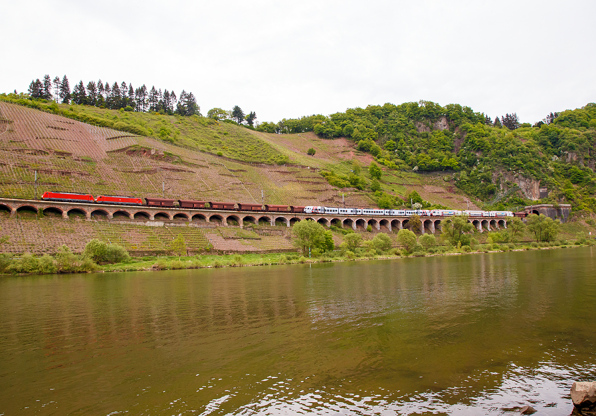 
W�hrend die 189 035-9 und 189 040-9 der DB Cargo Deutschland AG einen 5.500 Tonnen schweren Erzzug am 28.04.2018 auf dem P�ndericher Hangviadukt in Richtung Trier, mit dem Endziel Dillinger H�tte (Saar) ziehen. Fahren davor in Gegenrichtung (kurz vor der Einfahrt in den Prinzenkopftunnel) ein dreiteiliger CFL Stadler als RE 11  Benelux-Express  gekuppelt mit einem f�nfteiligen S�WEX Stadler als RE 1  S�dwest-Express  in Richtung Koblenz. 