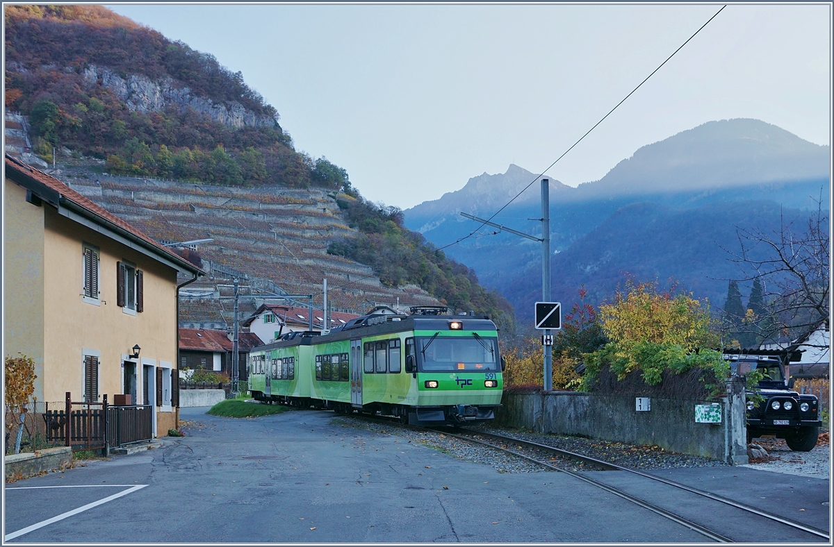 Während auf dem Berg schon die ersten Sonnenstrahlen angekommen sind verlässt im schattigen Tal kurz nach dem Bahnhof Aigle Château (vormals: Aigle Dépôt ASD) der TPC Beh 4/8 591 das ASD Eigentrasse und wird nun auf der Strasse die restlichen 1.1 Kilometer bis zum Bahnhof Aigle fahren. 
8. Nov. 2018