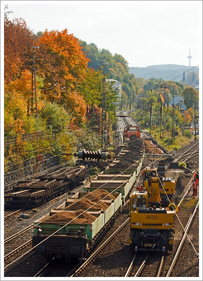 Weichenerneuerung am 19.10.2013 in Siegen-Weidenau an der KBS 440 (Ruhr-Sieg-Strecke) bei km 104 am Abzweig der KBS 445 (Dillstrecke), die hier nach links abzweigt. Ein Zweiwege-Bagger hebt den Altschotter aus und verl�d diesen auf die Seitenkippwagen, die die KSW Lok 42 (MaK 1700 BB) am Haken hat.
