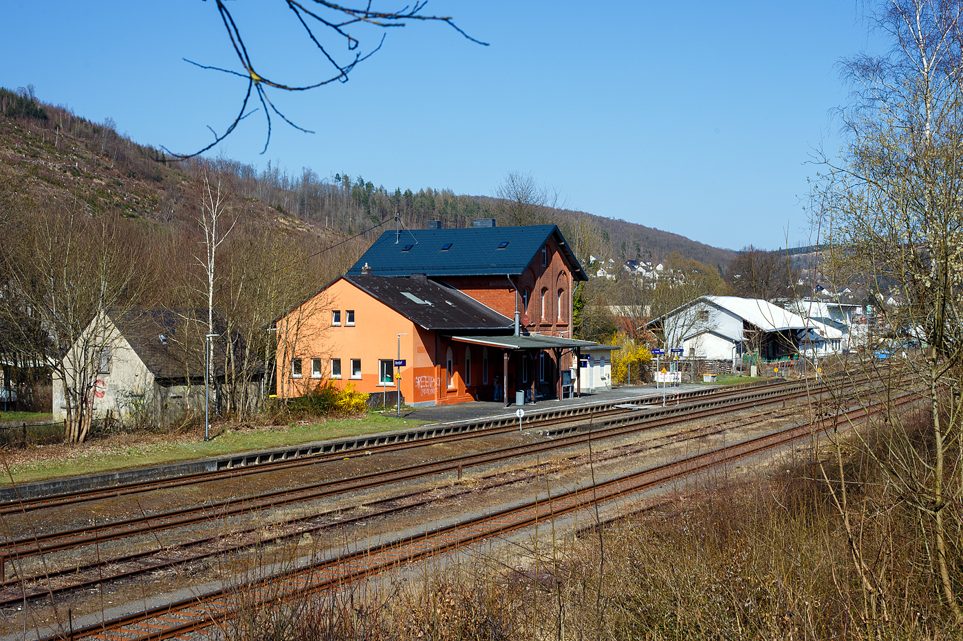 Blick auf das Empfangsgebäude Bahnhof Herdorf am 28 März 2025, von der Friedrichstraße über die Gleise hinweggesehen. Hinten rechts der ehemalige Güterschuppen. 

Der Bahnhof Herdorf liegt an km 90,1 der „Hellertalbahn“ KBS 462. 
