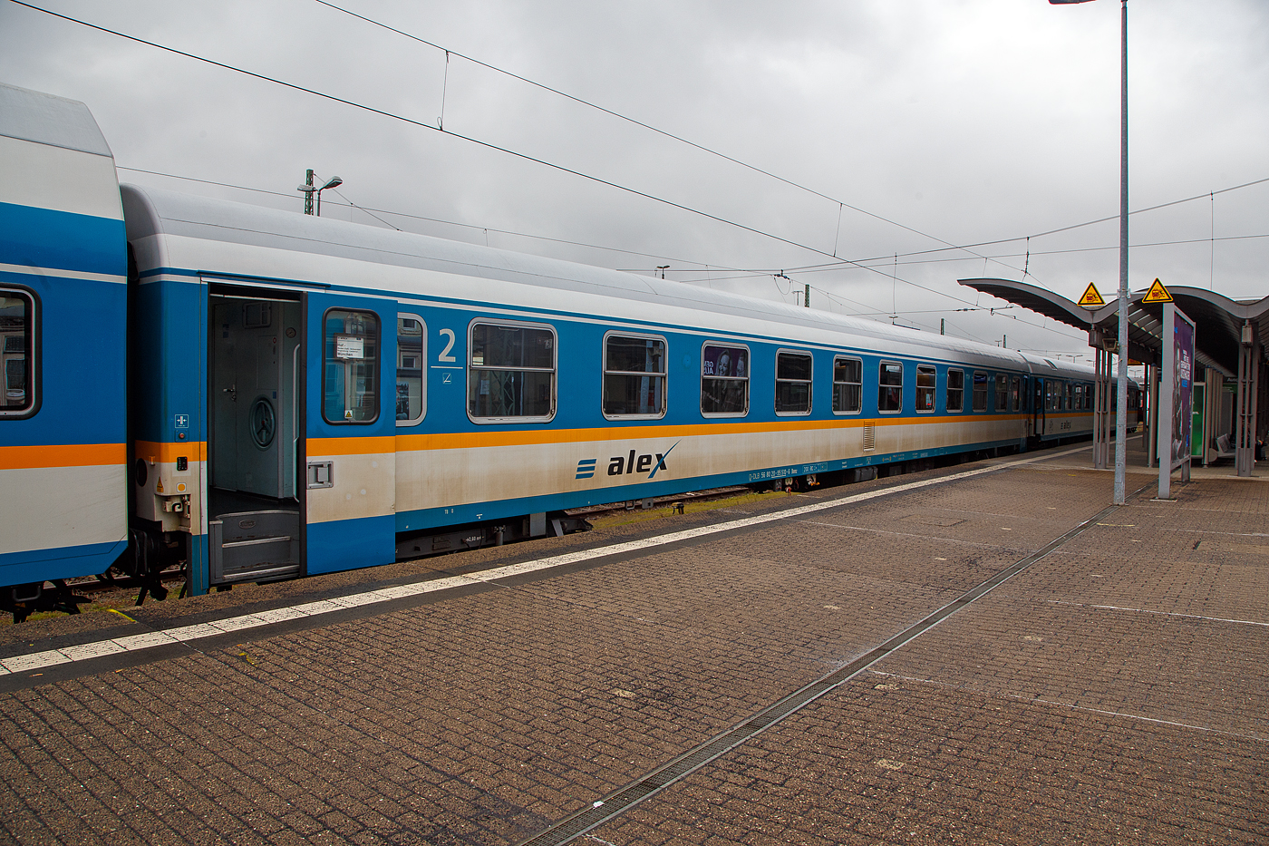 Der „alex“ zweite Klasse Reisezugwagen D-DBL 56 80 20-95 510-6 der Gattung Bomz (ex DB 51 80 10-94 009-7 Amz 210.0), der DBL - Die Länderbahn GmbH, eingereiht in einen RE nach München Hbf, am 17 April 2023 im Hbf Hof.

Die Wagen der ehemaligen Gattung Amz 210 und Amz 210.1 sind die jüngsten Fahrzeuge im Bestand des ALEX. Die Wagenserie entstand 1991 beim Waggonbau Bautzen (ehemals LOWA, später Deutsche Waggonbau AG (DWA), jetzt Bombardier) noch im Auftrag der Deutschen Reichsbahn. Sie entstanden nach dem Vorbild der Ame-Wagen des RAW Halberstadt (spätere Am 201) und den UIC-Z-Normen. Es wurden insgesamt 40 Wagen gebaut, die ab Werk im blauen Interregio-Farbschema lackiert waren, innen jedoch noch klassische Schnellzugwagen waren. Eingesetzt wurden sie bis 2002 im Interregioverkehr. Zum Schluss liefen sie teilweise noch in Regionalexpresszügen, im Jahr 2003 wurde diese Wagenserie (gerade einmal 12 Jahre alt!) komplett ausgemustert. 22 Wagen dieses Typs konnte die Regentalbahn von der DB kaufen, 2 Wagen wurden als Ersatzteilspender verwendet, so dass sich aktuell 20 Wagen im Bestand des ALEX befinden.

Drei der ehemaligen Amz 210 wurden nicht in ABvmz umgebaut, sondern als unklimatisierte Abteilwagen 2. Klasse hergerichtet, indem lediglich die alte Einrichtung im Design des neuen alex aufgearbeitet wurde. 

Zur Einsetzbarkeit: 
Die Wagen mit den Ziffern 90 an der 7. und 8. Stelle der Wagennummer sind mehrspannungsfähig, die Wagen mit den Ziffern 95 (wie dieser hier) an dieser Stelle sind nur einspannungsfähig - die Versorgung der Zugsammelschiene ist nur mit der in Deutschland üblichen Spannung von 1000V und 16 2/3 Hz möglich.

TECHNISCHE DATEN:
Hersteller: WB Waggonbau Bautzen 
Baujahr: 1991
Spurweite: 1.435 mm
Länge über Puffer: 26.400 mm
Wagenkastenlänge: 26.100 mm
Drehzapfenabstand: 19.000 mm
Achsstand im Drehgestell: 2.600 mm
Drehgestellbauart: GP 200-S-Mg
Leergewicht: 40 t
Höchstgeschwindigkeit: 200 km/h
Zulassungen: D (1000V 16 2/3 Hz)
Sitzplätze: 60 in der 2. Klasse in 10 Abteilen
Toiletten: 2
Bremsbauart: KE-GPR-Mg (D)