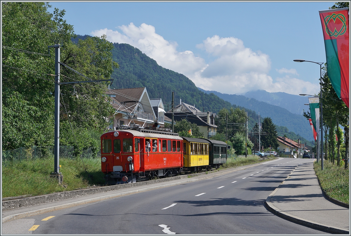 Der RhB ABe 4/4 35 der Blonay-Chamby Bahn erreicht mit den beiden RhB Salonwagen As2 N°2 und RhB Abteilwagen BC2 N° 121 als Riviera Belle Epoque Express von Chaulin nach Vevey den Bahnhof von Blonay. 

28. Juli 2024
