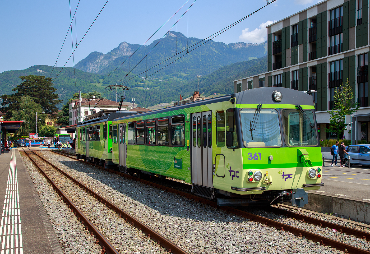 Der Triebwagen mit Gep�ckabteil BDeh 4/4 311 (ex 303)  „Yvorne“ und der Steuerwagen Bt 361 (ex 353) beide der tpc (Transports Publics du Chablais), ex bzw. Betriebsteil AL - Aigle-Leysin-Bahn, stehen am 28 Mai 2023 im Schmalspur-Bahnhof Aigle. Auch dieser Pendelzug tr�gt nun die neue TPC-Lackierung und nicht mehr die urspr�ngliche Lackierung der AL (creme-braun), nach der Neulackierung wurden auch nicht mehr die Wappen der Triebwagen angebracht.

Der Trieb- und Steuerwagen wurde 1987 von Vevey - Ateliers de constructions m�caniques de Vevey (ACMV) gebaut, die SLM (Schweizerischen Lokomotiv- und Maschinenfabrik) in Winterthur lieferte die Drehgestelle mit der Zahnradtechnik und die BBC (Brown, Boveri & Cie.) die elektrische Ausr�stung. Die ehemalige Fabrikhalle der ACMV steht heute noch in Vevey, siehe: http://hellertal.startbilder.de/bild/schweiz~hersteller~vevey-acmv-spaeter-vevey-technologies-sa/814732/die-ehemalige-fabrikhalle-des-1842-gegruendeten.html

Die Triebwagen BDeh 4/4 311 bis 313 (ex 303 bis 305) sind meterspurige elektrische Personentriebwagen mit Gep�ckabteil f�r gemischten Zahnrad- und Adh�sionsbetrieb (Zahnstangensystem Abt). Der Pendelzug (BDeh 4/4 mit Bt) besitzt nur die 2. Wagenklasse auf eine 1. Wagenklasse wurde verzichtet. 

Anfang der 1980er Jahren pr�sentierte sich das Rollmaterial der AL zwar in einem guten Zustand, doch gen�gte es den Komfortanspr�chen nur noch bedingt. Da auch die drei anderen Bahnen der TPC neues Rollmaterial ben�tigten, wurde ein gemeinsames Beschaffungskonzept erarbeitet. Schlie�lich fand im sechsten Rahmenkredit f�r Privatbahnhilfe des Bundes auch eine Rollmaterialbestellung f�r AL, AOMC und BVB Platz. 1984 wurden insgesamt drei neue Pendelz�ge f�r die AL (2 St�ck) und die BVB (1 St�ck) bei ACMV, SLM und BBC in Auftrag gegeben. Die bei der AL als BDeh 4/4 303-304 bezeichneten Fahrzeuge stellen eine Weiterentwicklung der BVB BDeh 4/4 81-82 dar und wurden mit 4 x 209 kW motorisiert. Wie die BDeh 4/4 301-302 haben sie eine Maximalgeschwindigkeit von 40 km/h, was aber f�r die AL-Verh�ltnisse gen�gt. Gleichzeitig mit den Triebwagen wurden 1987 auch zweipassende Steuerwagen Bt 353-354, die vom CEV Bt 223 abgeleitet wurden, in Betrieb genommen.

Mit den neuen Pendelz�gen hielt auch ein neues Erscheinungsbild bei der TPC Einzug. Die Fahrzeuge aller vier Eisenbahngesellschaften wurden in einheitlichem Design gestaltet, wobei die bahneigenen Farben beibehalten werden konnten (creme-braun f�r die AL). Ab 1989 hielt dieser Anstrich auch bei den �brigen Fahrzeugen der AL Einzug. 1993 wurde mit dem BDeh 4/4 305 und Bt 355 ein weiterer, praktisch baugleicher Pendelzug in Betrieb genommen.  Im Jahr 2002 erfolgte die Umzeichnung der Triebwagen BDeh 4/4  303 bis 305 in BDeh 4/4 311 bis 313, sowie der Steuerwagen Bt 353 bis 355 in Bt 361bis 363.

Auch wenn Triebwagen zusammen mit den Steuerwagen als Pendelz�ge konzertiert sind, so haben die Triebwagen trotzdem zwei F�hrerst�nde und k�nnen so auch alleine in beide Richtungen fahren.

TECHNISCHE DATEN:
Hersteller: (1987/1993) ACMV/SLM/BBC
Baujahr: 1987 (2 St�ck) / 1993 (1St�ck)
Spurweite: 1.000 mm
Fahrleitungsspannung: 1.500 V =
Maximale Streckenneigung: Adh�sion 38 ‰ / Zahnstange 230 ‰
Zahnstangensystem: Abt

TRIEBWAGEN:
Typ und Nummerierung: BDeh 4/4 311 – 313 (bis 2002 ex 303 bis 305)
Achsfolge: Bo'zz Bo'zz
L�nge �ber Puffer: 15.400 mm
Leistung: 4 x 209 kW = 836 kW (1.136 PS)
H�chstgeschwindigkeit: 40 km/h (Adh�sion) / 25 km (Zahnrad)
�bersetzung: 1:12,2
Gewicht: 35.8 t
Sitzpl�tze: 32
Stehpl�tze: 29
Max. Ladegewicht: k.A.

STEUERWAGEN:
Typ und Nummerierung: Bt 361–363 (bis 2002 ex Bt 353–355)
Anzahl der Achsen: 4
Gewicht: 10,0 t
Sitzpl�tze: 40
Stehpl�tze: 72
