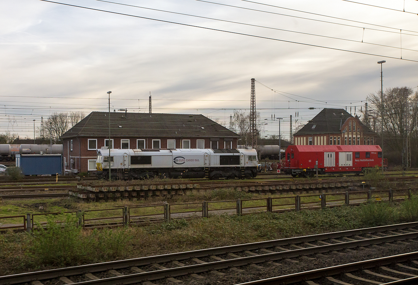 Die 077 003-7 (92 87 0077 003-7 F-DB) der DB Cargo AG, ex ECR 77 003 (Euro Cargo Rail SAS), steht am 14 März 2024 in Oberhausen-Osterfeld, aus einem fahrenden ICE heraus fotografiert. Davor steht noch ein Hilfszugwagen der DB Netz Notfalltechnik.

Die General Motors EMD JT42CWRM-100 (Class) wurde 2007 von EMD unter der Fabriknummer 20068864-003 gebaut und 2008 an die französische DB Tochter Euro Cargo Rail SAS (Paris) als 77004 (92 87 0077 004-5 F-ECR) geliefert.

Die EMD Variante JT42CWRM
Ab dem 1. Januar 2009 konnten gemäß einer EU-Richtlinie bezüglich Abgasnormen im EU-Raum keine Lokomotiven der Klasse 66 mehr zugelassen werden. Die Erfüllung der ab 2009 gültigen Abgasnormen der EU Stufe IIIa sowie das Bestreben, den sehr hohen Lärmpegel im Führerstand durch eine bessere Schallisolierung zu reduzieren, führten zur Entwicklung einer emissionsärmeren Variante unter der Bezeichnung JT42CWRM, die auch als Class 77 bezeichnet wird. Der Hersteller EMD legte Wert auf die Feststellung, diese Baureihe sei für den Einsatz in Kontinentaleuropa entwickelt worden. Deren nach Großbritannien gelieferte Variante trägt hingegen die Bezeichnung Class 66/9.

In Deutschland werden oft unter der Betreiber-Baureihe 247 bezeichnet, im deutschen Fahrzeugeinstellungsregister ist sie jedoch als Baureihe 1 266.4 geführt.

Bei nahezu unverändertem Leistungsprofil ergab sich durch zusätzliche Einbauten ein Massezuwachs von nahezu 5.000 kg, das teilweise durch ein um 1.400 Liter reduziertes Tankvolumen kompensiert wurde. Durch ein Untersetzungsgetriebe an den Fahrmotoren und ein Gleitschutz konnte die Haftreibung auf nassen Schienen verbessert werden. 
