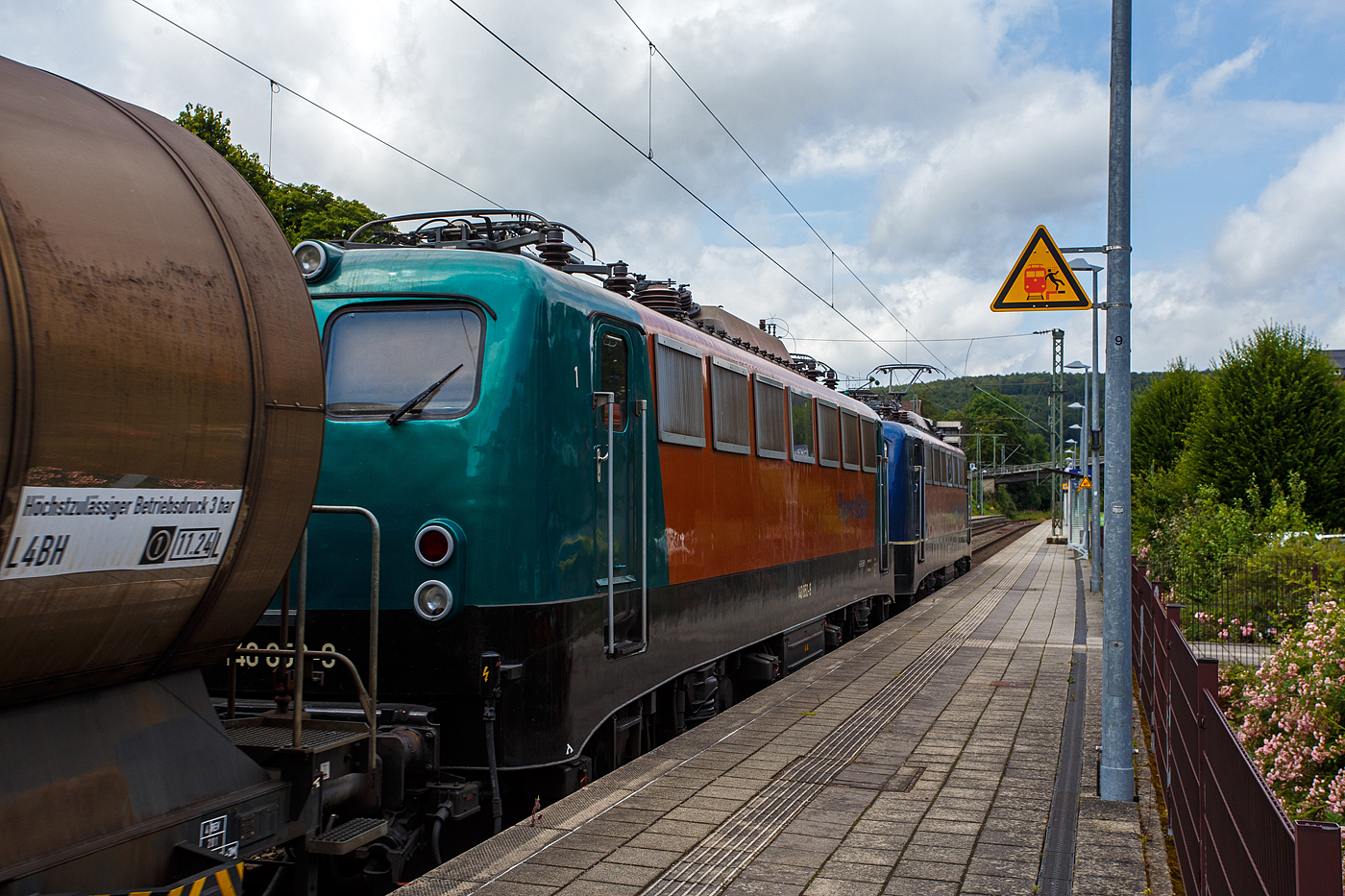 Die 139 287-7 (91 80 6139 287-7 D-BYB) mit der kalten 140 850-9 (91 80 6140 850-9 D-BYB) beide von der BayernBahn GmbH fahren am 04 Juli 2024 mit dem sogenannten  Henkelzug  (Langenfeld/Rhld. nach Gunzenhausen), durch den Bahnhof Kirchen (Sieg) in Richtung Siegen.

Die 139 287-7:
Vorne die 139 287-7 wurde 1963 von Krauss-Maffei AG in München-Allach unter der Fabriknummer 18956 gebaut, er elektrische Teil ist von den Siemens-Schuckert-Werke (SSW) in Berlin. Als DB E10 287 wurde in Dienst gesetzt, mit der Einführung des EDV-Nummernsystems wurde sie zum 01.01.1968 zur DB 110 287–0. Die Lok ist mit Einholmstromabnehmern ausgerüstet, sie ist die letzte gebaute Kasten 110er. Zur 139er wurde sie erst 1994 nach einem Umbau, der Lokkasten wurde auf Drehgestelle der Baureihe 140 (E40) gesetzt und es folgte die Umzeichnung in DB 139 287-7. Zum Mai 2009 erfolgte die Z-Stellung bei der DB AG. Zum 1.Oktober 2011 wurde die Lok durch die BayernBahn GmbH erworben und erhielt anschließend eine Untersuchung. Die Neulackierung in kobalt-blau/orange erhielt sie dann 2017.

Die 140 850-9
Die (E40) 140 850-9 wurde 1972 bei Henschel & Sohn in Kassel unter der Fabriknummer 31696 gebaut, der elektrische Teil wurde von der AEG in Berlin unter der Fabriknummer 8804 geliefert/gebaut. Als 140 850-9 wurde sie an die Deutsche Bundesbahn ausgeliefert, die Ausmusterung bei der DB Cargo AG erfolgte im Juli 2017 und sie wurde an die BayernBahn GmbH in Nördlingen verkauft.