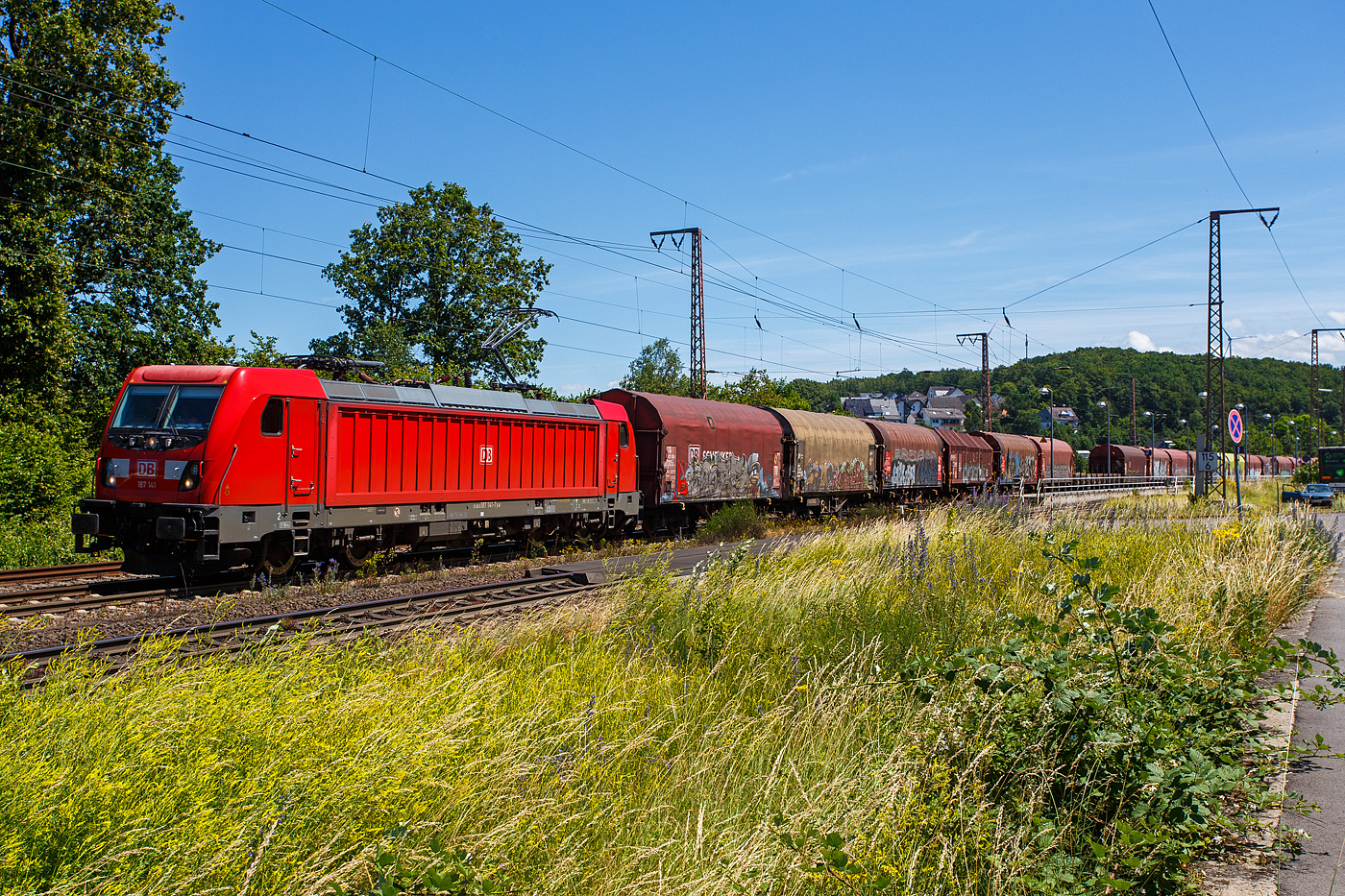 Die 187 141 (91 80 6187 141-7 D-DB) der DB Cargo AG f�hrt am 28 Juni 2024, mit einem gemischten G�terzug durch Rudersdorf (Kreis Siegen) in Richtung Siegen bzw. Kreuztal.

Die Bombardier TRAXX F140 AC3 wurde 2017 von der Bombardier Transportation GmbH in Kassel unter der Fabriknummer  35439 gebaut. Die TRAXX F140 AC3 Varianten der DB Cargo (BR 187.1) haben keine Last-Mile-Einrichtung. Die H�chstgeschwindigkeit betr�gt 140km/h. Die Lok hat nur die Zulassung f�r Deutschland. Die Lokomotiven k�nnen in gemischter Mehrfachtraktion mit BR185 und BR186 eingesetzt werden.