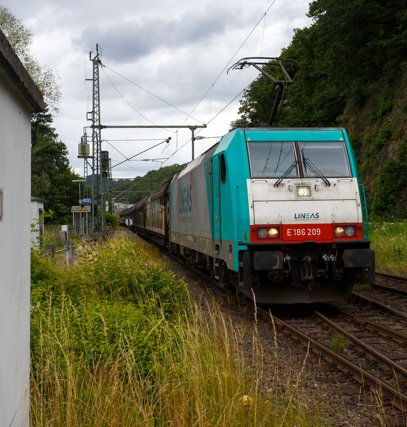 Die an die LINEAS Group NV/SA vermietete E 186 209 (91 88 7186 209-3 B-ATLU) der Alpha Trains Belgium NV/SA, ex Cobra 2817, f�hrt am 01 Juli 2024 mit einem langen gemischten G�terzug durch ScheuerfeldSieg in Richtung K�ln.

Die Bombardier TRAXX F140 MS wurde 2008 von Bombardier in Kassel unter der Fabriknummer 34395 gebaut und an die ATC - Angel Trains Cargo NV/SA (Antwerpen) ausgeliefert. Die Multisystemlokomotive hat die Zulassungen bzw. besitzt die L�nderpakete f�r Deutschland, �sterreich, Belgien und die Niederland (D/A/B/NL).

Lebenslauf und Bezeichnungen der Lok:
• Von 2008 bis 2010 NMBS /SNCB - Nationale Maatschappij der Belgische Spoorwegen / Soci�t� Nationale des Chemins de Fer Belges / Nationale Gesellschaft der Belgischen Eisenbahnen als 2817 (91 88 7186 209-3 B-B) bzw. Cobra 2817, sp�ter B Logistics NV/SA, ab LINEAS Group NV/SA.
• Von 2018 bis 2020 fuhr sie als E 186 209 (91 88 7186 209-3 B-XRAIL) f�r die Crossrail Benelux N.V.
• Seit Februar 2021 f�hrt sie nun wieder f�r die LINEAS Group


Die Traxx F140 MS geh�rt zur dritten Traxx-Generation, in Deutschland wird sie als Baureihe 186 bezeichnet. Es handelt sich dabei grob betrachtet um eine Weiterentwicklung der Traxx F140 MS2, also eine Viersystemlok f�r Wechsel- und Gleichstromsysteme mit 5.600 kW Nennleistung, die Drehgestelle und Antriebe wurden nochmals verbessert, so dass mit dem Tatzlagerantrieb erstmals eine regul�re H�chstgeschwindigkeit von 160 km/h erreicht werden kann. Auch die BR 186 ist mit verschiedenen L�nderpaketen erh�ltlich.

Geht man nach der Herstellerbezeichnung, handelt es sich bei der BR 186 um eine G�terzuglok, jedoch ist sie dank ihrer nachtr�glich f�r genehmigte H�chstgeschwindigkeit von 160 km/h auch f�r Eins�tze im Personenverkehr geeignet. Trotz der Geschwindigkeitserh�hung hat die Baureihe die  140  in der Bezeichnung Traxx F140 behalten. In Polen und �sterreich darf weiterhin nur bis zu 140 km/h schnell gefahren werden, diese Lok darf in auch nur 140 km/h fahren.

TECHNISCHE DATEN:
Spurweite: 1.435 mm (Normalspur)
Umgrenzungsprofil: UIC 505-1
Achsanordnung: Bo’Bo’
L�nge �ber Puffer: 18.900 mm
Max. Breite des Lokkastens: 2.977 mm
H�he �ber Stromabnehmer: 4.283 mm
Drehzapfenabstand: 10.440 mm
Achsabstand im Drehgestell: 2.600 mm
Dienstgewicht: ca. 86 t (abh�ngig von L�nderpaketen)
Radsatzlast :21.5 t
Antriebssystem: Tatzlagerantrieb
Anzahl Fahrmotoren: 4
Max. Leistung: 5.600 kW
Max. Anfahrzugkraft: 300 kN
zul. H�chstgeschwindigkeit in D und A: 140 km/h
zul. H�chstgeschwindigkeit in B und NL: 160 km/h
Netzspannungen: 25 kV AC 50 Hz, 15 kV AC 16,7 Hz, 3 kV und 1,5 kV DC
