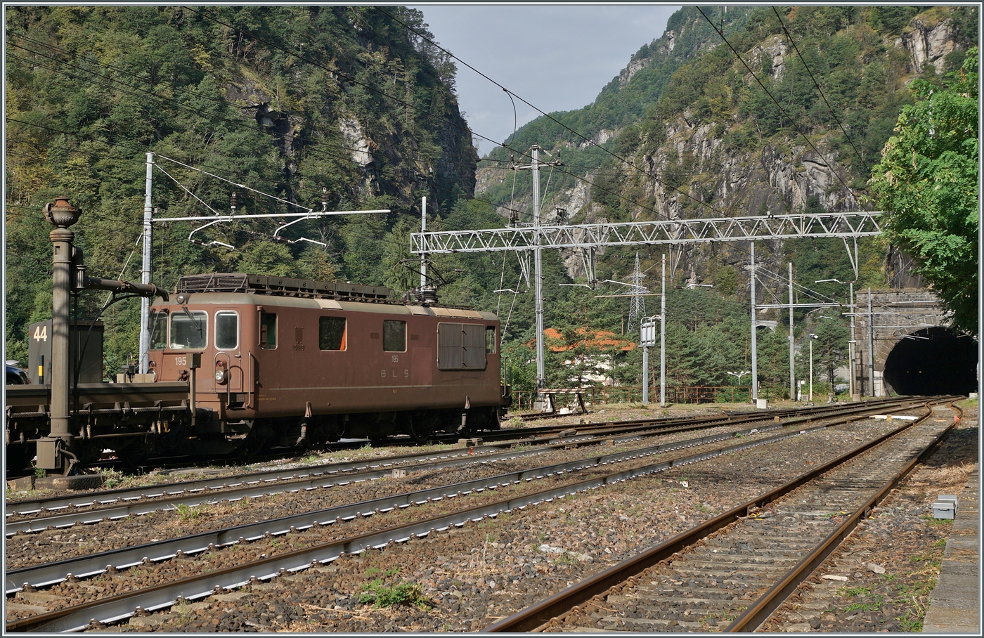 Die BLS Re 4/4 195 verlässt mit ihrem Autotunnelzug AT3 Iselle di Trasquera in Richtung Brig. 

17. August 2024