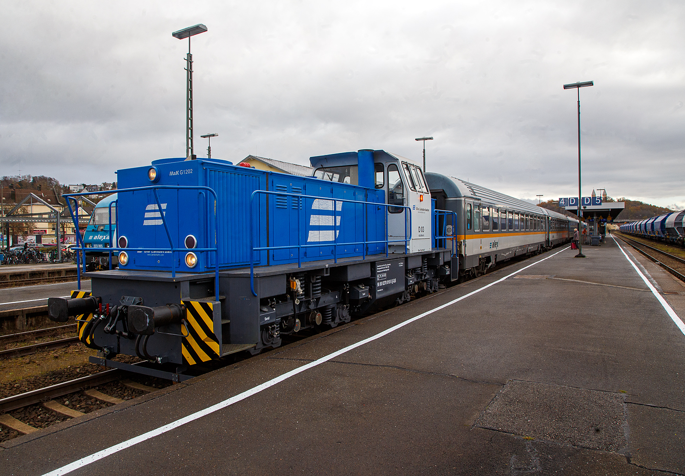 Die D 03 alias 270 010-8 (98 80 0270 010-8 D-DLB) eine MaK G 1202 BB der DLB - Die Länderbahn GmbH, ex D III der Regentalbahn AG, hat am 24.11.2022 im Bahnhof Schwandorf den weiter als RE 25 geführten alex-Zug bereitgestellt. 

An dem seitlichen gelben Licht am Führerhaus, kann man erkennen, die Lok wird über die Funk-Fernsteuerung gesteuert wird. Aus betriebsbedingten Gründen wurde für den alex RE 25 (Praha – Plzeň - Furth i.W. - Schwandorf – Regensburg – München), in Tschechien als EC 360 / Ex 6 geführt, in Schwandorf ein anderer Zug für die Weiterfahrt über Regensburg nach München bereitgestellt. So musste man umsteigen und den Bahnsteig 2 auf 4 wechseln.

Die MaK G 1202 BB wurde 1980 von MaK in Kiel unter der Fabriknummer 1000789 gebaut und am die Regentalbahn AG geliefert.
Seit 2015 firmieren die Töchter der Regentalbahn als DLB - Die Länderbahn GmbH.

Die Lokomotive MaK G 1202 BB ist eine dieselhydraulische Lokomotive, die von der Maschinenbau Kiel (MaK) gebaut wurde. Sie hat eine Leistung von 1.000 kW (ältere 945 kW) und erreicht eine maximale Geschwindigkeit von 60 km/h. Das Dienstgewicht der Lok beträgt ja nach Aufführung 72 - 88 t, diese hier hat durch Ballastgewichte ein Dienstgewicht von 80 t (ohne Zusatzgewichte 72 t). Die leistungsstärkere G 1202 BB war deutlich erfolgreicher als die G 1201 BB. Als ab 1981 die stärkeren MTU-Motoren der Reihe 396 eingebaut wurden, wurde die Typenbezeichnung in G 1204 BB geändert. 

TECHNISCHE DATEN:
Gebaute Anzahl: 12
Spurweite:  1.435 mm (Normalspur)
Achsformel:  B'B'
Länge über Puffer: 12.500 mm
Drehzapfenabstand: 5.800 mm
Achsabstand im Drehgestell:  2.400 mm
größte Breite: 3100 mm
größte Höhe über Schienenoberkante: 4.220 mm
Raddurchmesser neu: 1.000 mm 
kleinster befahrbarer Gleisbogen: 60 m
Dienstgewicht: 80 t (ohne Ballastgewichte 72 t)
Kraftstoffvorrat: 2.500 l
Motor: MTU-V12-Zylinder-Dieselmotor mit Common-Rail-Einspritzung, Abgasturboaufladung und Ladeluftkühlung vom Typ MTU 12V 396 TC12  (ältere MTU 12V 331 TC11)
Leistung: 1.000 kW (ältere 945 kW)
Getriebe: Voith L5r4U2
Höchstgeschwindigkeit: 60 km/h (andere Ausführungen 40 – 75 km)