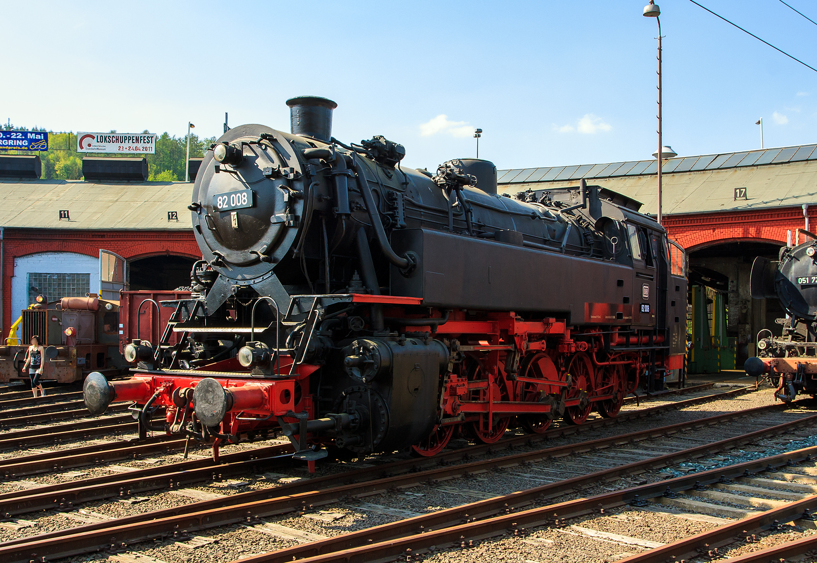 Die DB 82 008 (ex DB 082 008-4) am 23.04.2011 im Südwestfälische Eisenbahnmuseum in Siegen.

Die Lok wurde 1951 bei Krupp in Essen unter der Fabriknummer 2884 gebaut und als 82 008 an die DB geliefert, 1968 wurde sie in DB 082 008-4 umgezeichnet. Die Ausmusterung bei der DB erfolgte am 18.04.1972.

Bis 2014 stand sie (als Leihgabe) im Südwestfälische Eisenbahnmuseum in Siegen, seit April 2014 ist sie nun im DB Museum Koblenz-Lützel zu sehen.

Zum Einheitslok-Typenprogramm der Deutschen Bundesbahn (DB) gehörte auch die fünfachsige Güterzugtenderlokomotive der Baureihe 82. Sie war für den Rangier- und Streckendienst vorgesehen und sollte die fünffach gekuppelten Länderbahnbauarten ablösen, aber auch die durch das komplexe Laufwerk Schad anfällige Einheitslokomotiven der DR-Baureihe 87.

Die Baureihe 82 wurde als erste Neubaulokgattung der DB zwischen 1950 und 1951 von den Unternehmen Krupp und Henschel und in einem weiteren Baulos 1955 von der Maschinenfabrik Esslingen gefertigt.

Bei der Konstruktion versuchte man eine gleichermaßen gut für den Rangier- wie Streckendienst geeignete Maschine zu schaffen. Nach dem bisherigen Stand der Technik widersprachen die für beide Dienste maßgeblichen Konstruktionskonzepte einer gleichwertigen Eignung für beide Dienstbereiche. Dieser Widerspruch sollte durch einen Kessel moderner Bauart und die besondere Laufwerkskonstruktion beseitigt werden.

Um ohne die für eine reine Rangierlokomotive überflüssigen Laufradsätze die für den Streckendienst auch bei höheren Geschwindigkeiten notwendigen sicheren, ruhigen und gleisschonenden Laufeigenschaften zu erhalten, entschied man sich nach Vorversuchen mit einer umgerüsteten preußischen T 16 dazu, das jeweils äußere Kuppelradsatzpaar zu einem Beugniot-Lenkgestell zu vereinigen. Bisherige laufradsatzlose Fünfkuppler-Tenderlokomotiven mit Radsatzanordnung nach Gölsdorf wie etwa die T 16 hatten sich nämlich als für höhere Geschwindigkeiten über rund 40 km/h aufgrund des ausgesprochen unruhigen Laufes als wenig geeignet erwiesen.

Mit den Beugniot-Lenkgestellen waren die Maschinen zugleich ohne die aufwendige Laufwerkstechnik der Baureihe 87 in der Lage enge Gleisbögen (R=100 m), wie z.B. auf der Hamburger Hafenbahn, einwandfrei zu durchfahren.

Bei der Auslegung des Kessels entschied man sich für einen geschweißten Kessel mit großer Strahlungsheizfläche, aber ohne Verbrennungskammer, damit dieser sowohl unter den unregelmäßigen Leistungsanforderungen im Rangierdienst als auch bei Spitzen- und hohen Dauerleistungen im Streckendienst standfest blieb.

Bei der Dimensionierung der Zylinder, die bei einer Rangierlokomotive wegen der aufzubringenden großen Kräfte mit kleinem Durchmesser, bei einer Streckenlokomotive hingegen zur Ausnutzung der Dampfdehnung großvolumig auszulegen gewesen wären, entschied man sich für einen Kompromiss. Dieser führte allerdings, wie vom Bauartdezernenten Friedrich Witte vorhergesagt, zu einem erhöhten Brennstoffverbrauch. Im Rangierdienst schwankte der Mehrverbrauch zur T 16 um 10 bis 19 %, im Streckendienst sogar um 30 %.

Beim Laufwerk wurde nur der dritte Treibradsatz, fest im Rahmen gelagert. Die beiden jeweils außen liegenden Kuppelradsatzpaare verband man mit Beugniot-Hebeln zu jeweils einem Lenkgestell. Die Endradsätze waren um insgesamt 52 mm seitlich verschiebbar, der zweite bzw. vierte Kuppelradsatz noch um insgesamt 36 mm.

Die Lokomotiven der Baureihe 82 bewältigten eine Wagenzugmasse von 800 t in der Ebene mit 70 km/h. Auf Steigungen von 10 Promille konnten noch 400 t mit 40 km/h befördert werden.

Belegt sind Einsätze vor allem auf den Rangierbahnhöfen in Bremen und Hamm sowie den Hafenbahnen von Emden und Hamburg. Im Streckendienst konnten die 82er auf den Steilrampen Siegerland und Westerwald und im Schwarzwald auf der Murgtalbahn beobachtet werden.

Neben einem hohen Schmierölverbrauch bemängelte der Betriebsdienst an der Baureihe 82 vor allem außer den problematischen Heißdampfreglern und schlecht funktionierenden Strahlpumpen einen raschen, durch Verschmutzung bedingten, Verschleiß der Lenkgestelle.

Die Ausmusterung begann bereits 1966, Auslauf-Bw war Koblenz-Mosel, wo die letzte Maschine dieses Typs 1972 abgestellt wurde. Die Baureihe war damit früher aus dem Dienst geschieden als die Baureihe 94, welche sie ja ersetzen sollte.
Fast alle Lokomotiven dieser Baureihe wurden nach Einsatzende verschrottet, lediglich die hier gezeigte 82 008 stellte man 1974 als Denkmal am Bahnhof Lingen (Ems) auf, sie gelangte so in den Bestand des DB Museums. Nach Stationen in Neumünster (2003-2010) und Siegen (2010-2014) befindet sie sich nunmehr im DB Museum Koblenz.

Technische Daten der Baureihe 82:
Gebaute Anzahl: 41 (DB 82 001 - 041)
1435 mm (Normalspur)
Achsformel / Bauart: E h2t
Gattung: Gt 55.18
Länge über Puffer: 14.060 mm
Höhe: 4.450 mm
Gesamtachsstand: 6.600 mm
Leergewicht: 69,7 t
Dienstgewicht: 87 t
Achslast:17,4 t
Höchstgeschwindigkeit: 70 km/h (vorwärts / rückwärts)
Leistung: 1.290 PSi (949 kW)
Treibraddurchmesser: 1.400 mm
Steuerungsart: Heusinger
Zylinderanzahl: 2
Zylinderdurchmesser : 600 mm
Kolbenhub: 660 mm
Kesselüberdruck: 14 bar
Anzahl der Heizrohre: 113
Anzahl der Rauchrohre: 38
Heizrohrlänge: 4.000 mm
Rostfläche: 2,39 m2
Überhitzerfläche: 51,90 m2
Verdampfungsheizfläche: 122,21 m2
Kohlenvorrat: 4 t
Wasservorrat: 11 m3
Seit 1960 ist die 82 008 mit einer Riggenbach-Gegendruckbremse ausgerüstet.

Quellen: wikipedia, eisenbahn-museumsfahrzeuge.de
