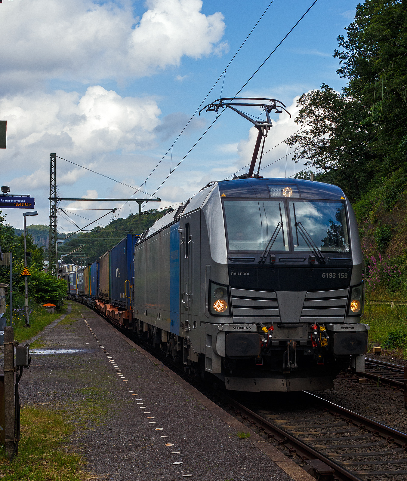 Die SIEMENS Vectron AC 6193 153-4 (91 80 6193 153-4 D-Rpool) der Railpool GmbH (M�nchen) f�hrt am 19 Juni 2024 mit einem KLV-Zug durch Scheuerfeld/Sieg in Richtung K�ln.

Die Wechselstromlok (AC 15 kV 16,7 Hz und AC 25 kV 50 Hz) SIEMENS Vectron AC wurde 2023 von Siemens Mobilitiy in M�nchen-Allach unter der Fabriknummer 23498 gebaut. Sie wurde in der Vectron Variante AC B18 ausgef�hrt und hat so die Zulassung f�r Deutschland, �sterreich, Schweden, Norwegen und D�nemark (D / A / S / N und DK). 

So besitzt die Variante AC B18 folgende  Zugsicherungssysteme:
ETCS BaseLine 3, sowie f�r Deutschland (PZB90 / LZB80 (CIR-ELKE I)), f�r �sterreich (ETCS Level 1 mit Euroloop, ETCS Level 2, PZB90 / LZB80), 
f�r Schweden und Norwegen (ATC-2 (L10000)) und f�r D�nemark ZUB 123.

TECHNISCHE DATEN der Vectron AC B18:
Spurweite: 1.435 mm
Achsformel: Bo'Bo'
L�nge �ber Puffer: 18.980 mm
Drehzapfenabstand: 9.500 mm
Achsabstand im Drehgestell: 3.000 mm
Breite: 3.012 mm
H�he: 4.248 mm
Raddurchmesser : 1.250 mm (neu) / 1.160 mm (abgenutzt)
Gewicht: 90 t
Spannungssysteme: AC 15 kV 16,7 Hz und AC 25 kV 50 Hz (Wechselstrom)
Max. Leistung am Rad: 6.400 kW (Fahren und Netzbremse)
Leistungsfaktor: nahe 1
H�chstgeschwindigkeit: 200 km/h
Anfahrzugskraft: 320 kN
Elektrische Bremskraft: 240 kN (erh�hte E-Bremskraft)
Kraft�bertragung: Ritzelhohlwellenantrieb
Kleinster befahrbarer Bogenradius (Strecke):	R 140 m
Kleinster befahrbarer Bogenradius (Depot): R 80 m
